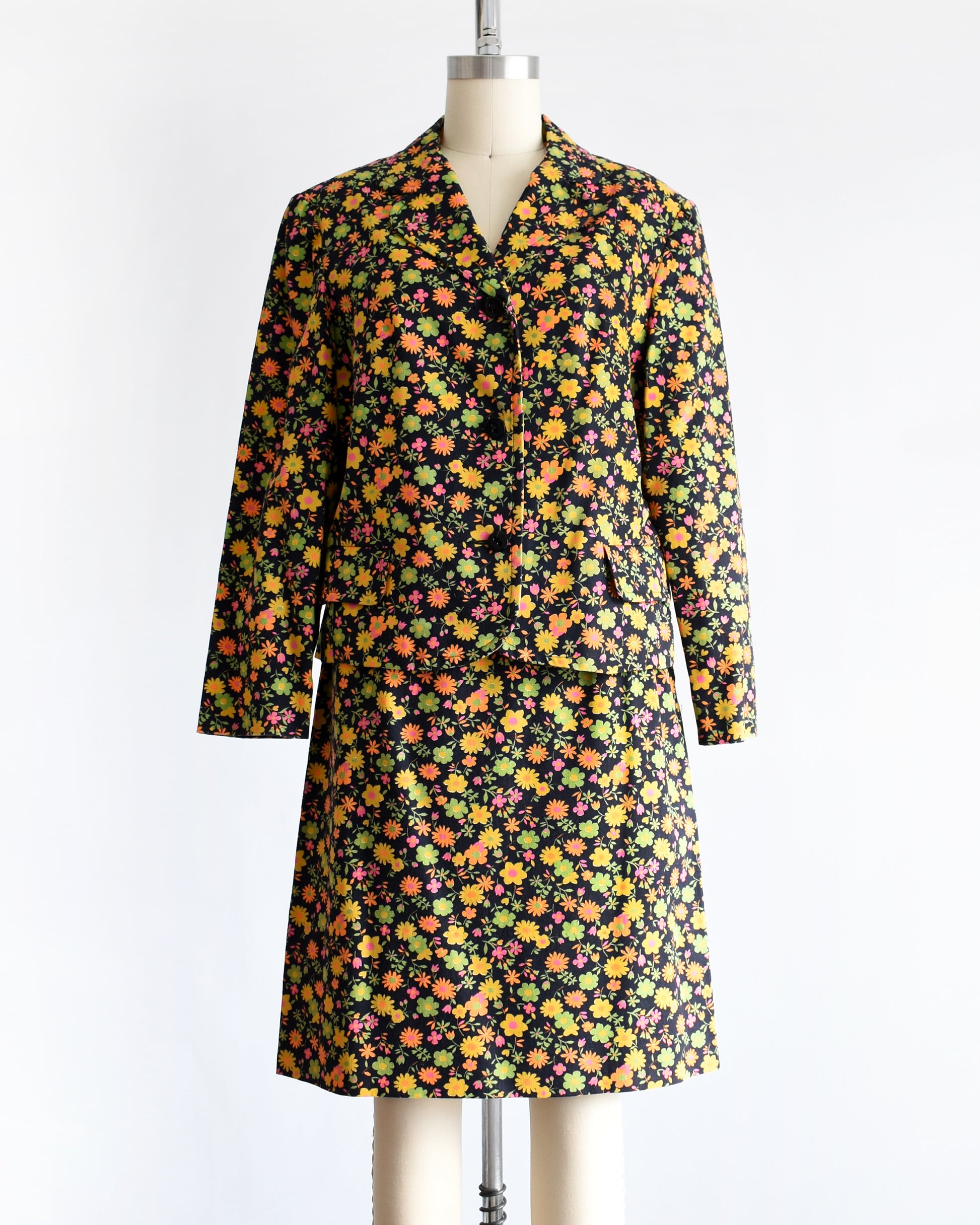 a vintage 1960s/1970s matching floral  blazer and skirt on a mannequin against a white background