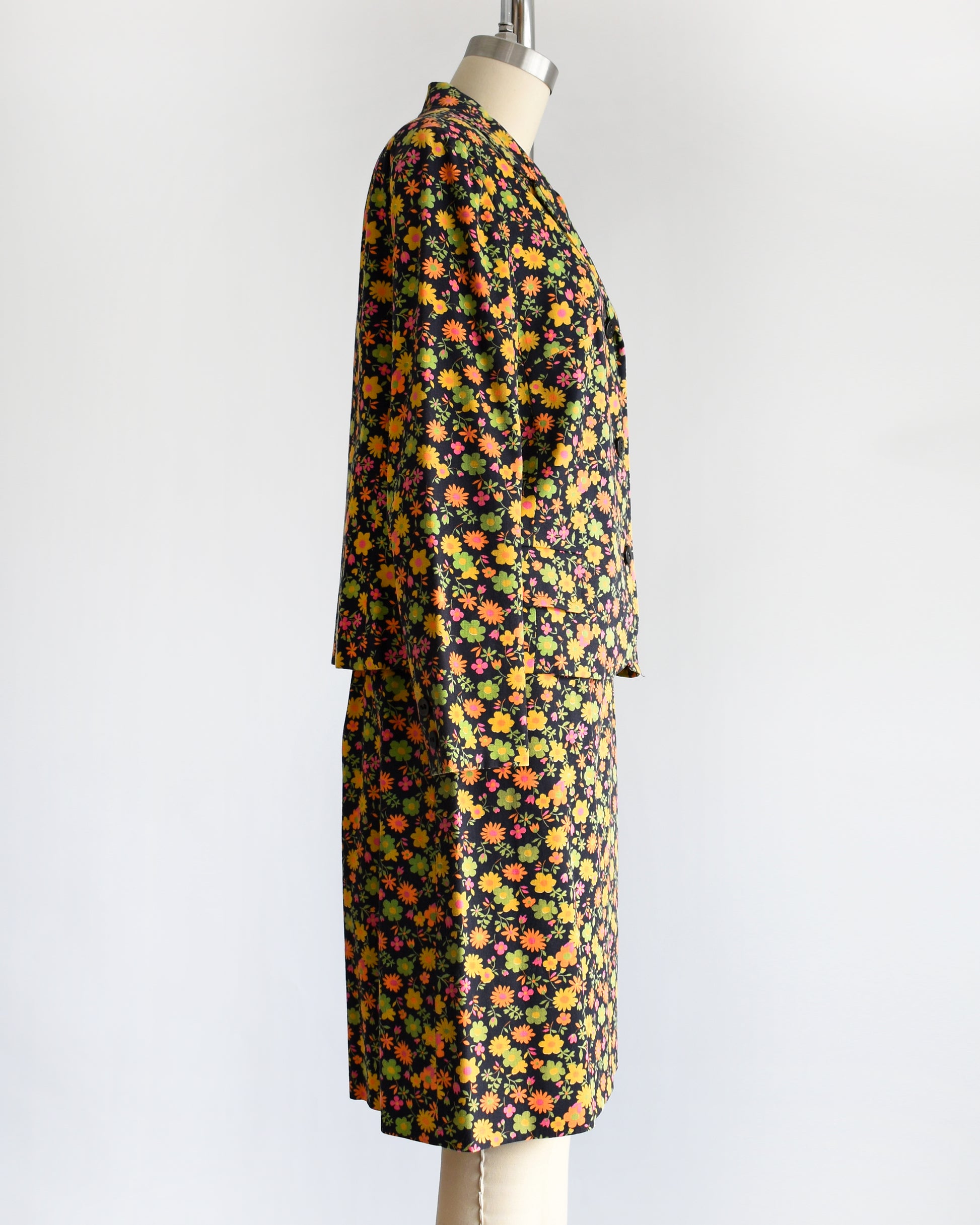 side view of a vintage 1960s/1970s matching floral  blazer and skirt on a mannequin against a white background