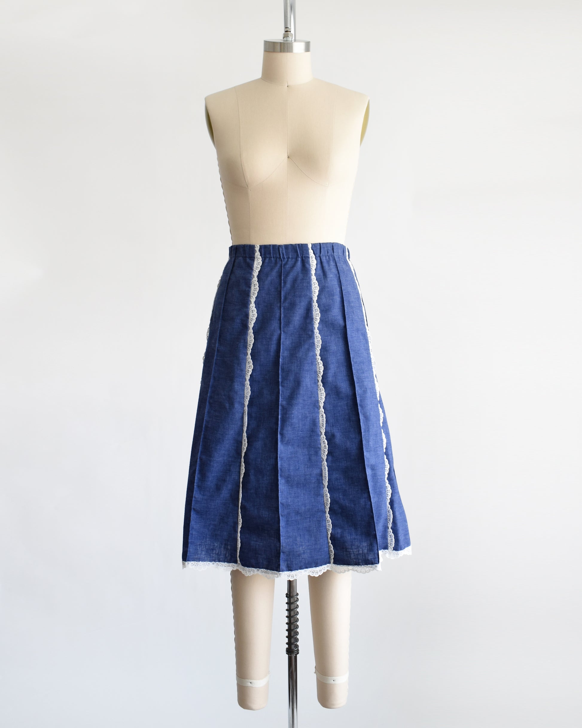 a vintage 1970s blue chambray lace skirt on a dress form against a white background