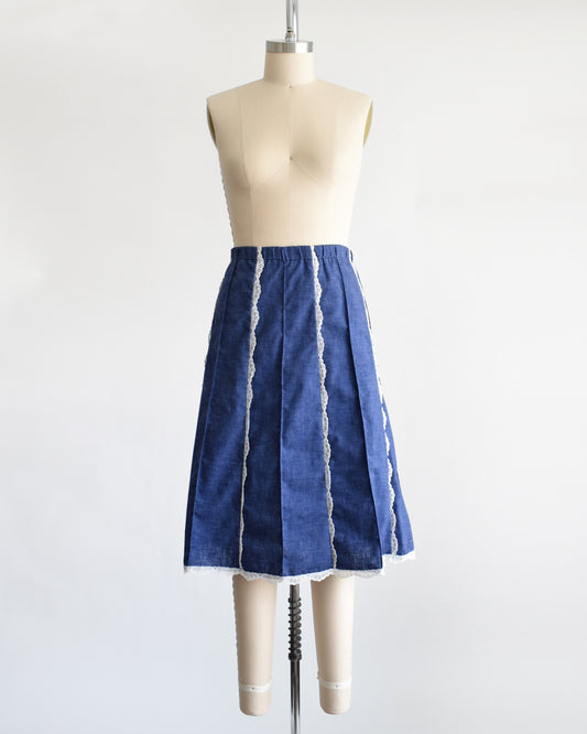 a vintage 1970s blue chambray lace skirt on a dress form against a white background