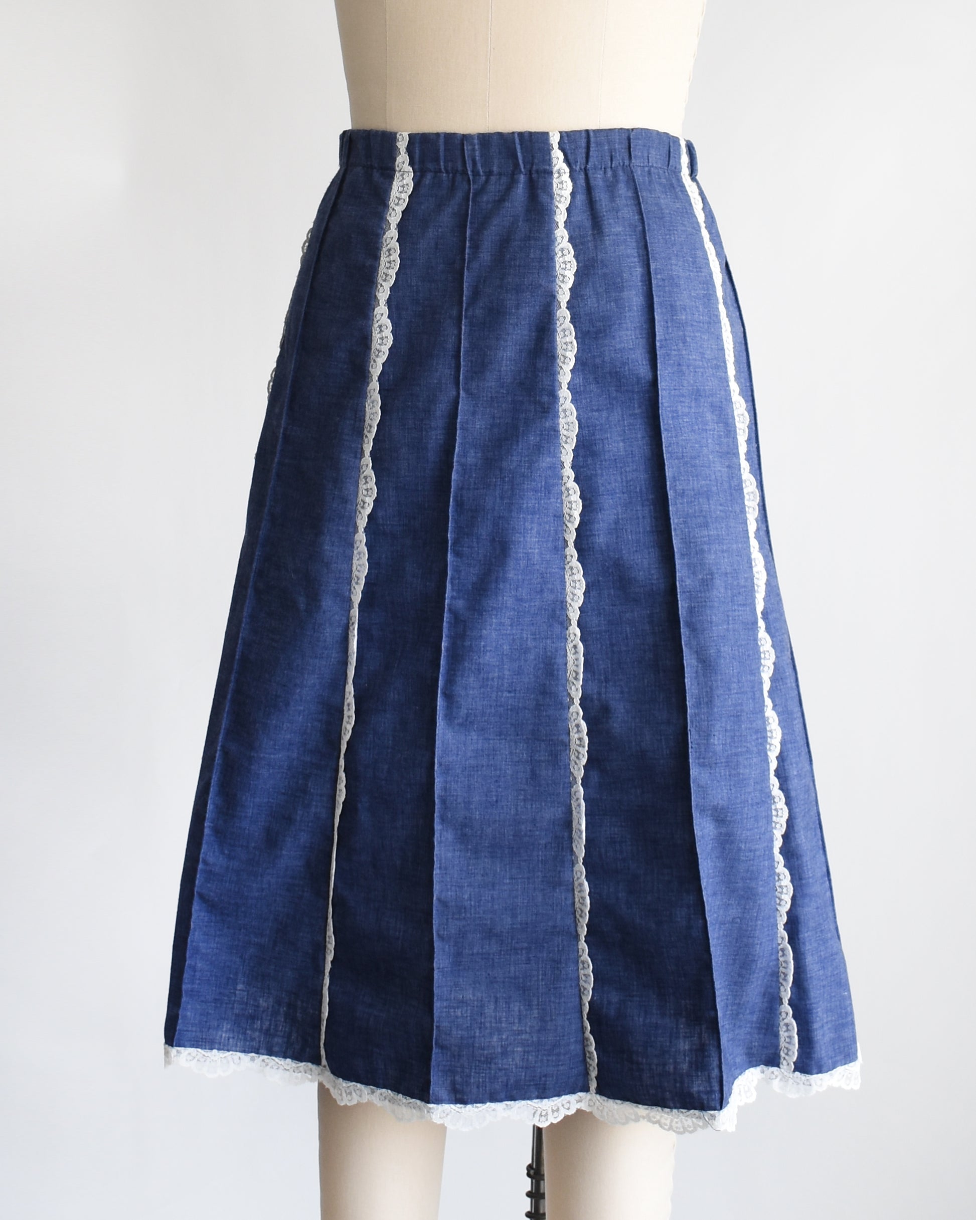 side front view of a vintage 1970s blue chambray lace skirt on a dress form against a white background