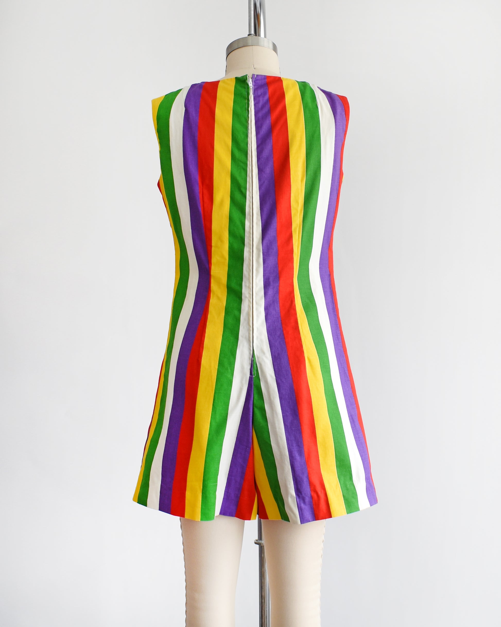 back view of a vintage 1960s rainbow striped romper on a dress form. there is a white belt around the waist which is not included.