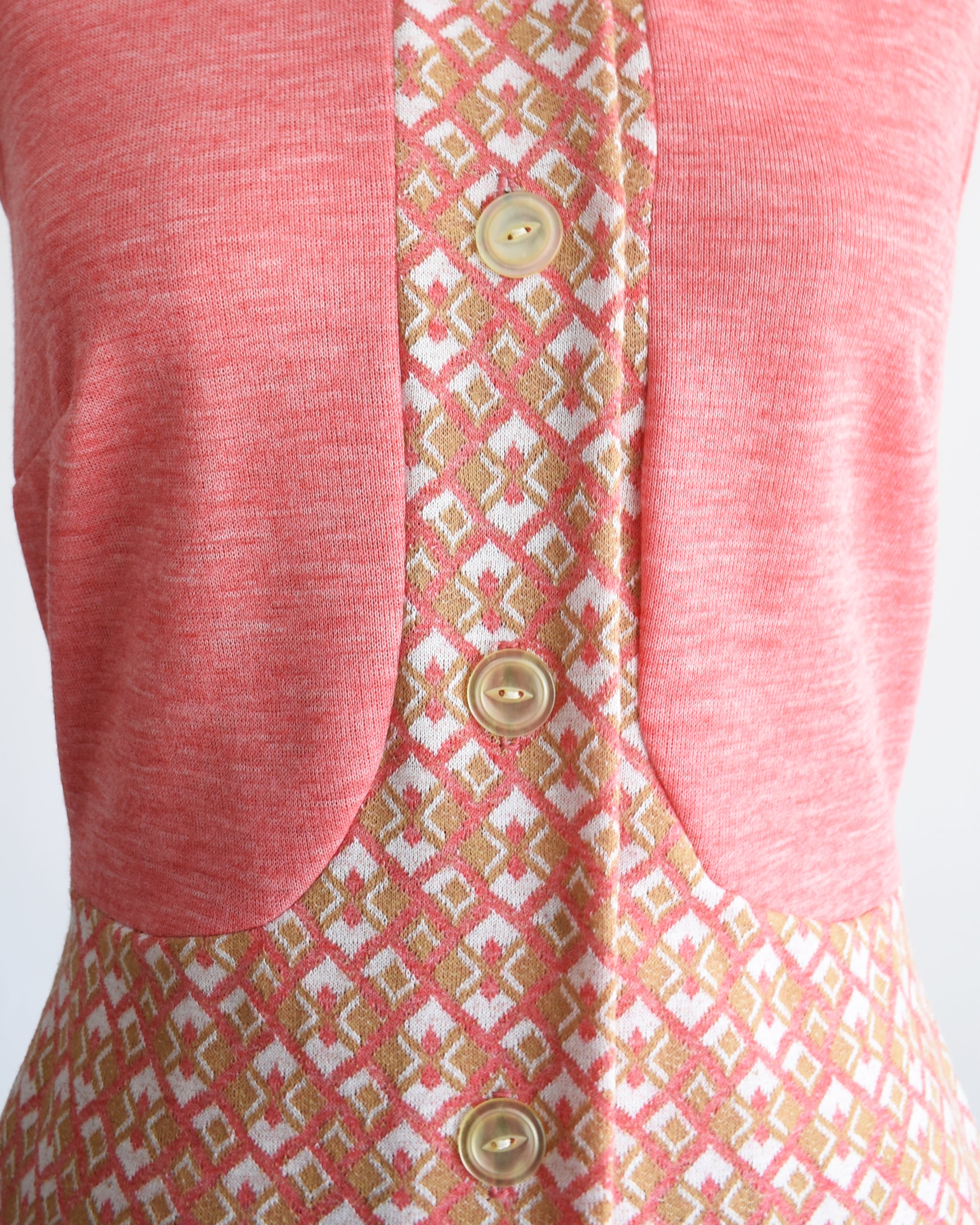 close up of the bodice of the dress showing the buttons and geometric pattern