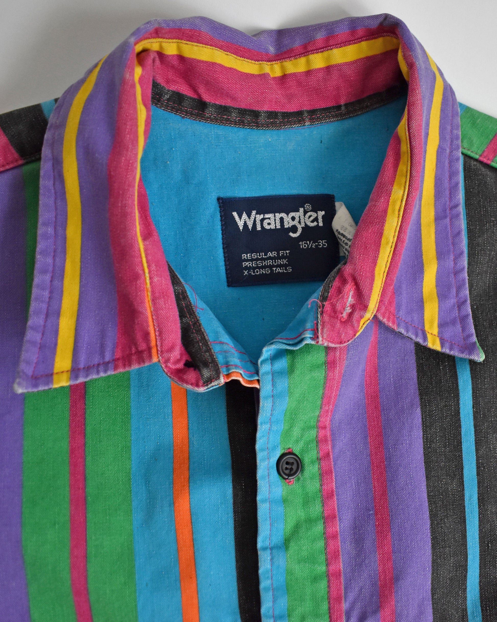 close up of the Wrangler tag on a vintage 90s Wrangler Brushpopper multicolored striped shirt on a white background