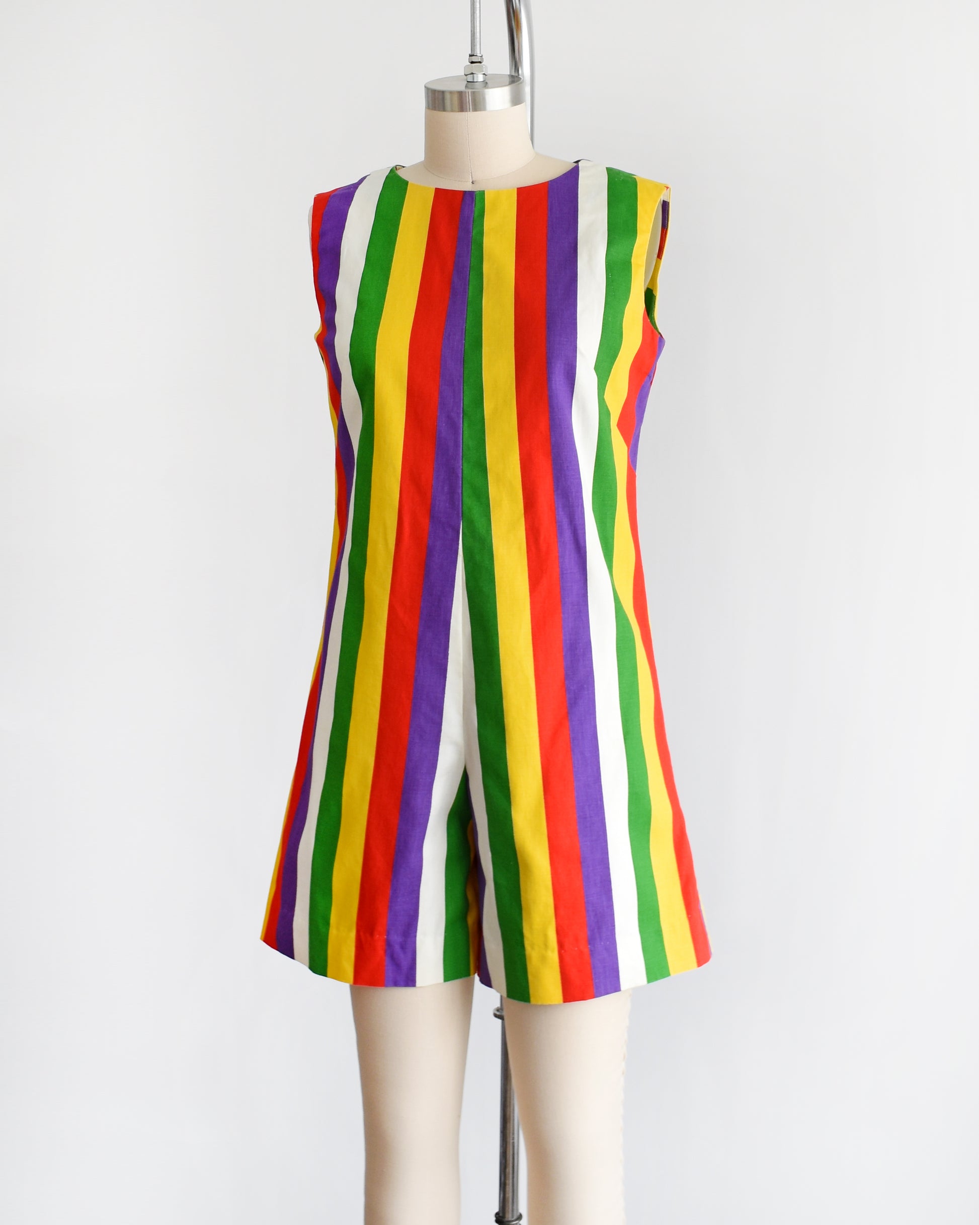 side front view of a vintage 1960s rainbow striped romper on a dress form.