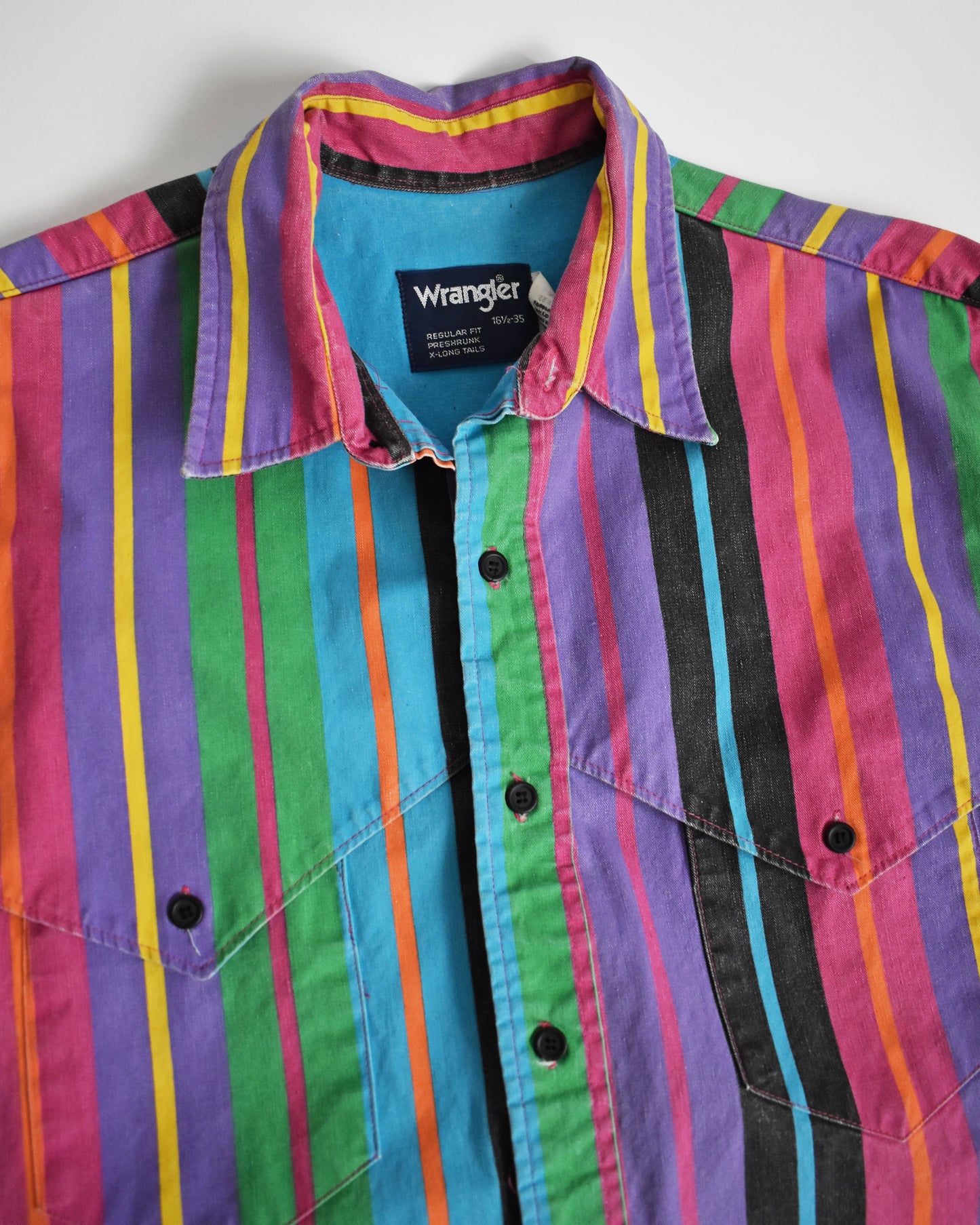 the collar area on a vintage 90s Wrangler Brushpopper multicolored striped shirt on a white background