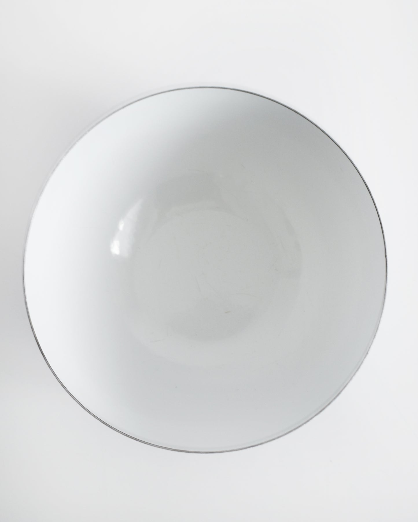 overhead shot of a vintage blue and white striped Cathrineholm bowl on a white background