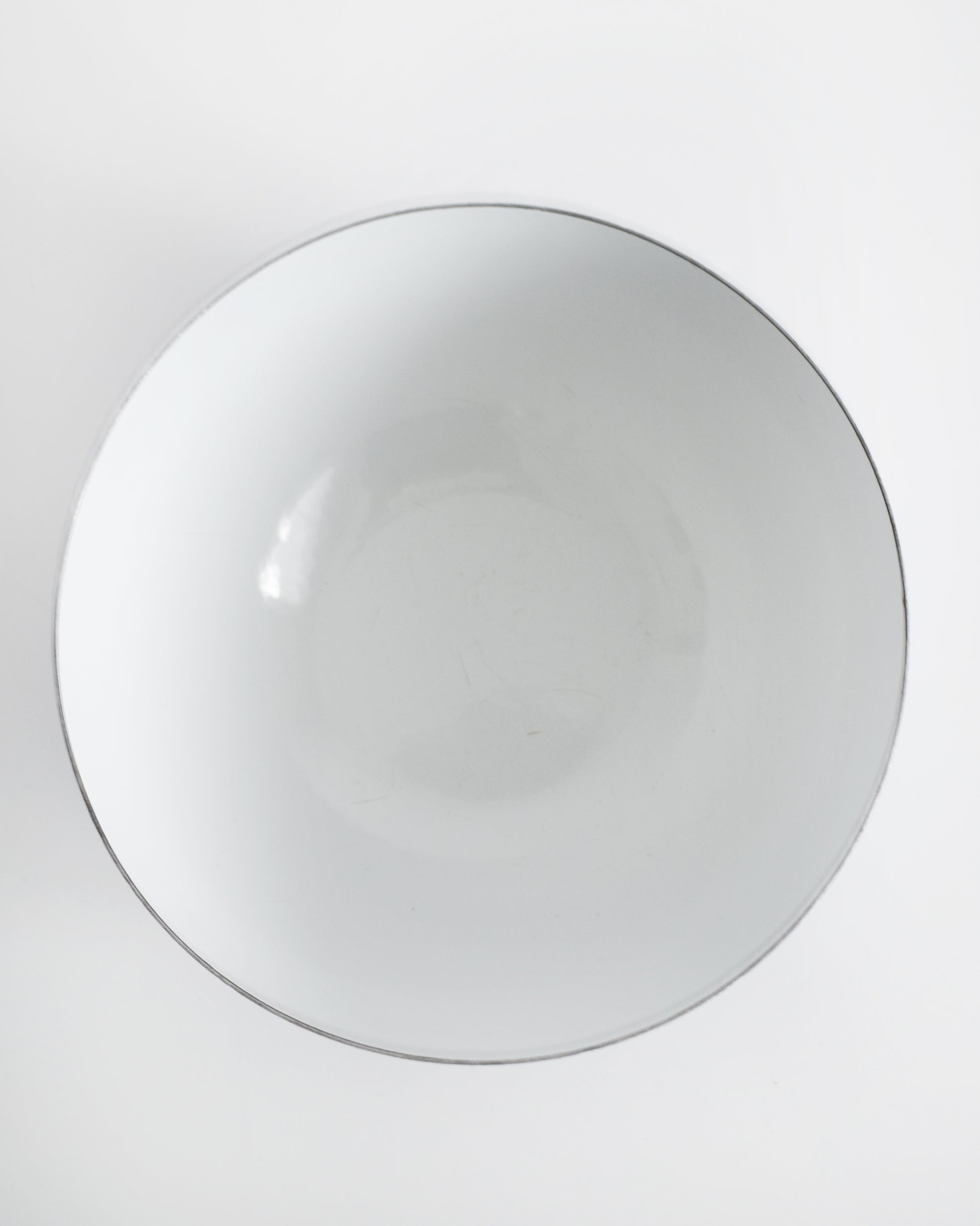 overhead shot of a vintage blue and white striped Cathrineholm bowl on a white background