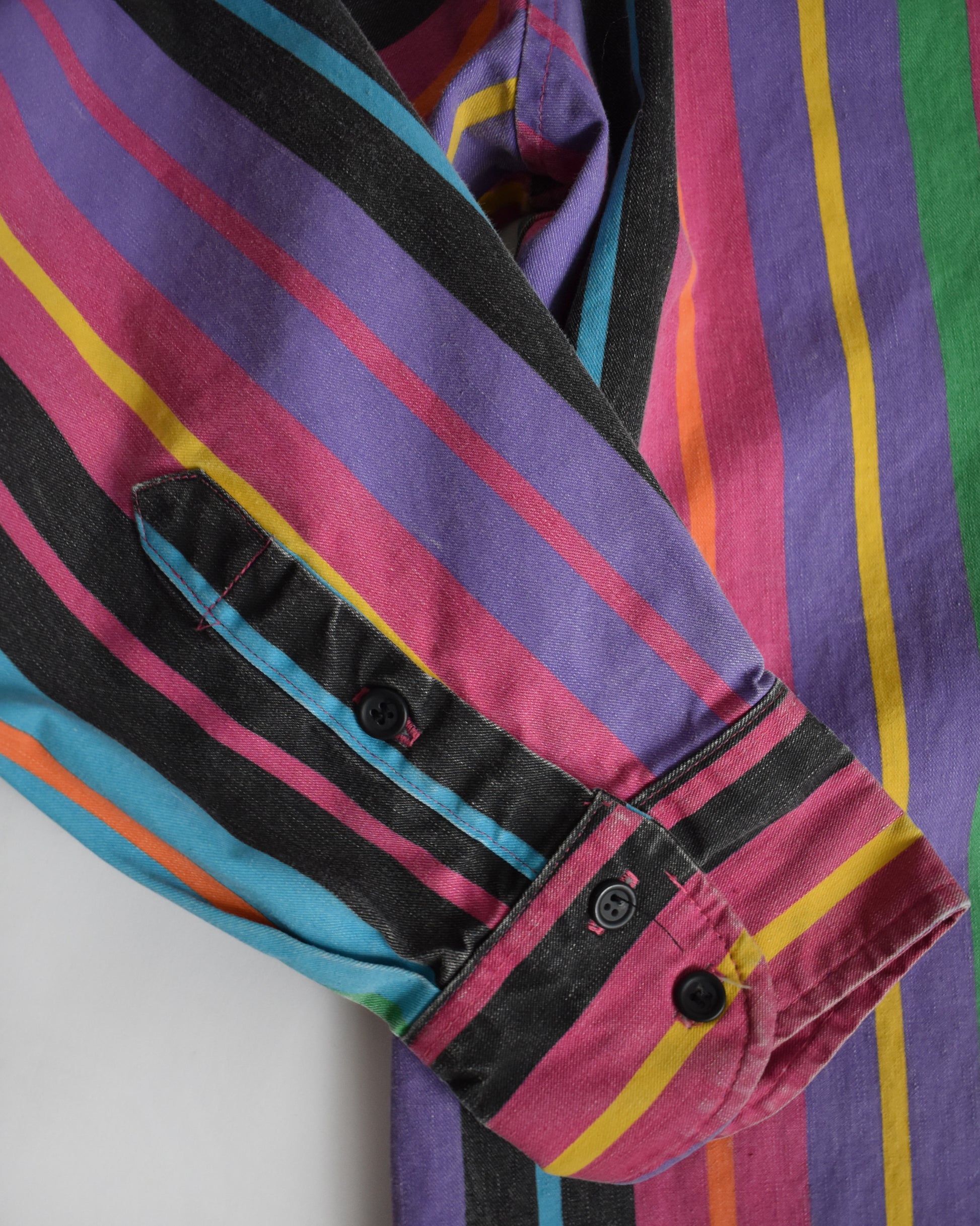 the sleeve cuff on a vintage 90s Wrangler Brushpopper multicolored striped shirt on a white background