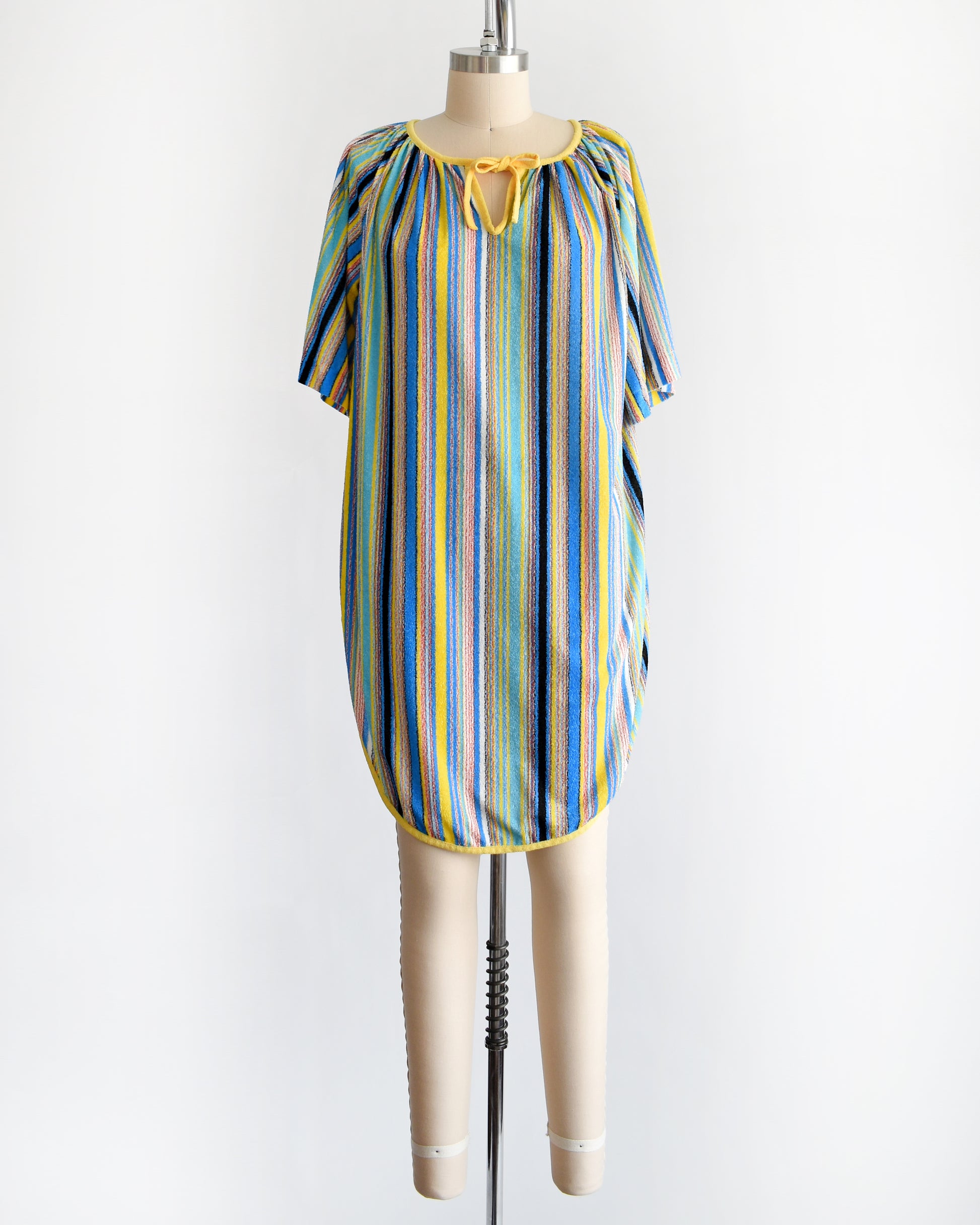 a vintage 1970s striped terry cloth cover-up dress. the neckline has a yellow tie creating a keyhole cutout underneath