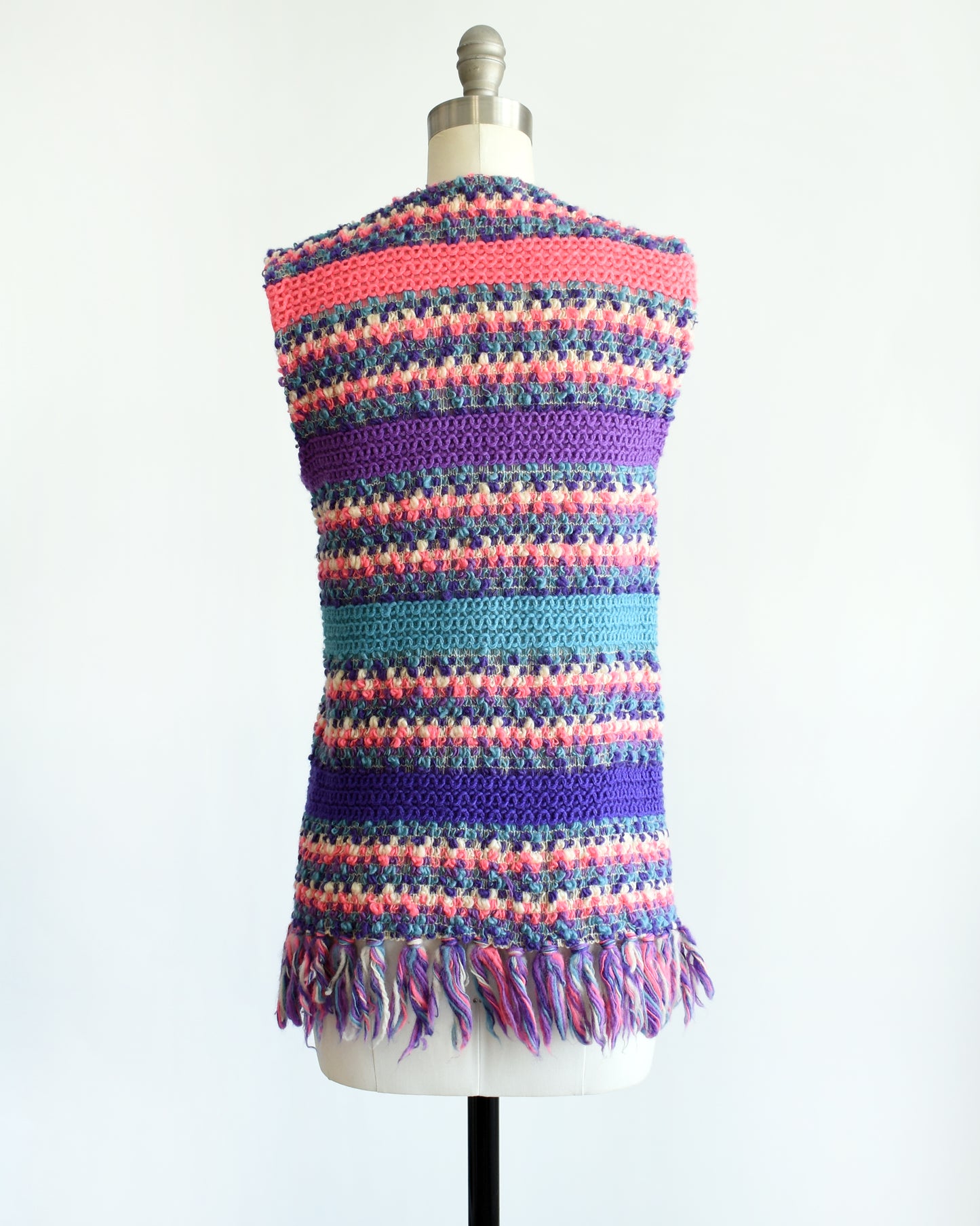 back view of a vintage 1960s/1970s multicolored striped crochet vest on a mannequin against a white background