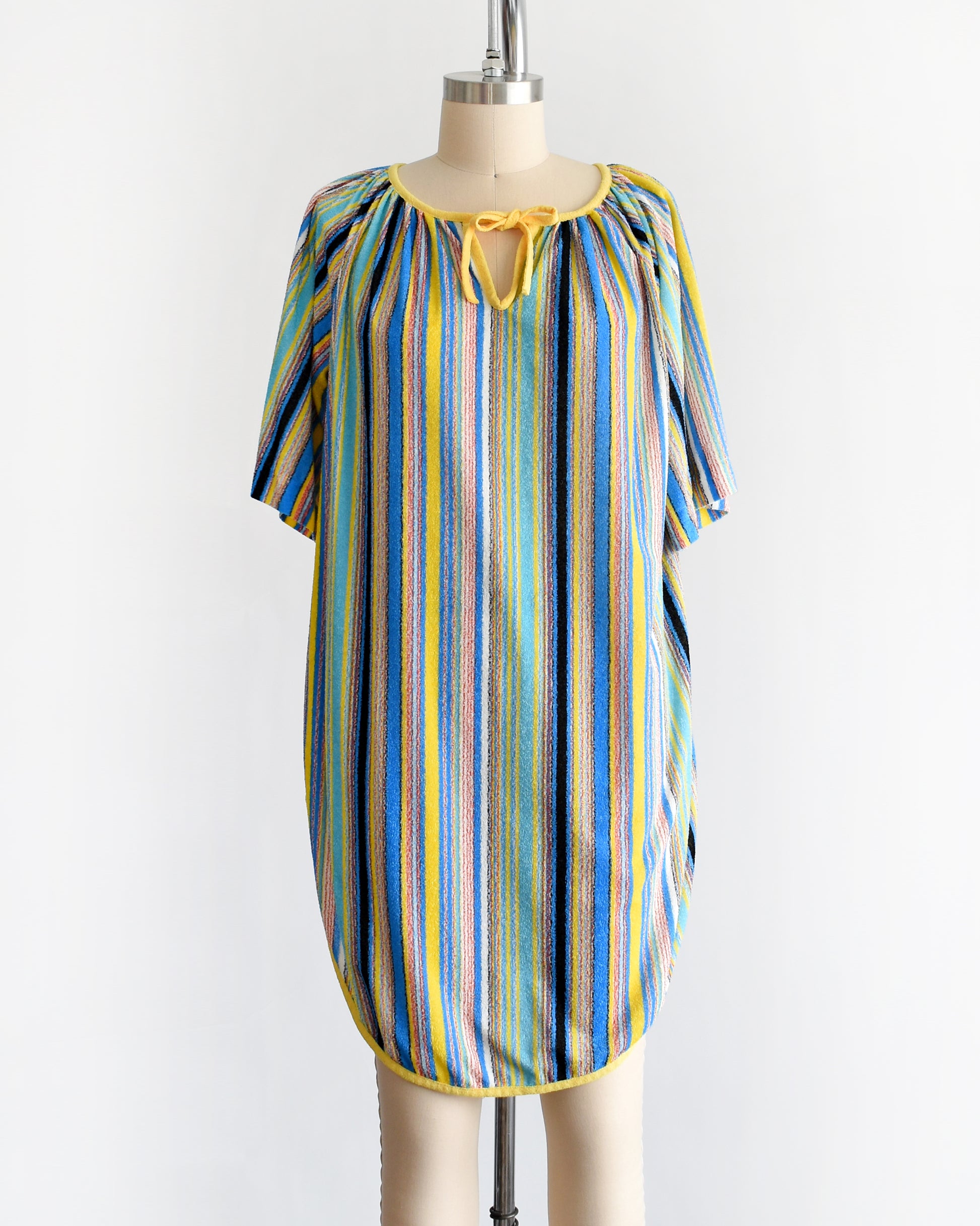 a vintage 1970s striped terry cloth cover-up dress. the neckline has a yellow tie creating a keyhole cutout underneath