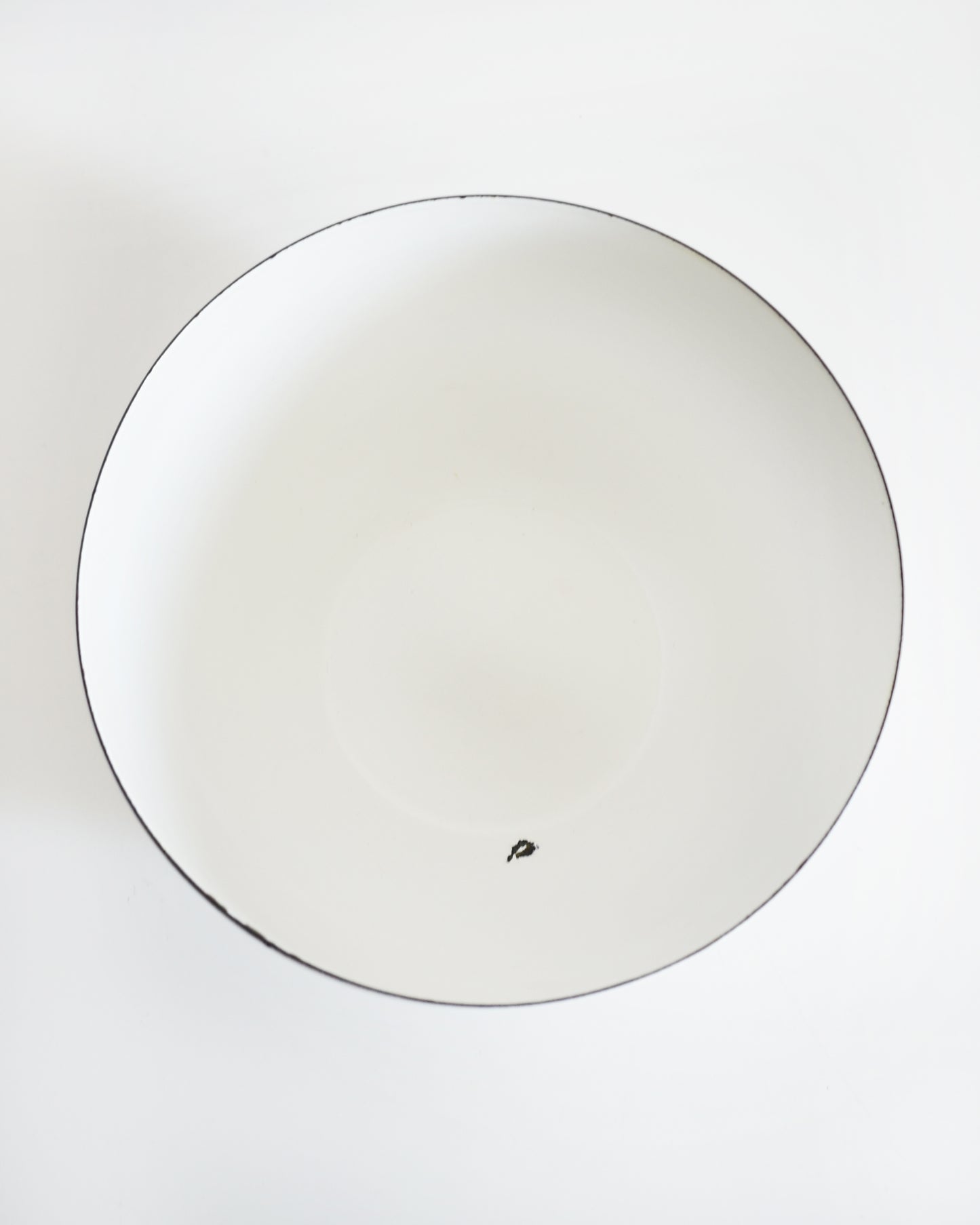 overhead shot of a a vintage Kaj Franck for Arabia Finland vegetable & fruit enamel bow. a spot of enamel is missing on the inside