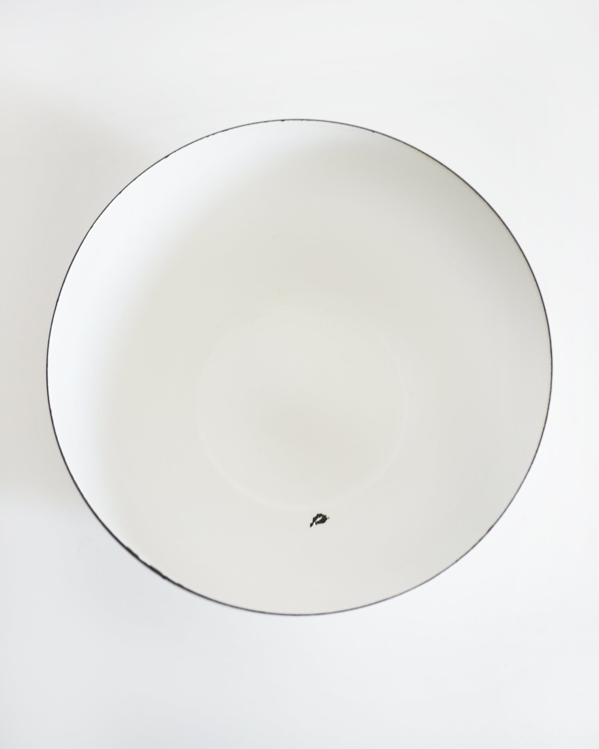 overhead shot of a a vintage Kaj Franck for Arabia Finland vegetable & fruit enamel bow. a spot of enamel is missing on the inside