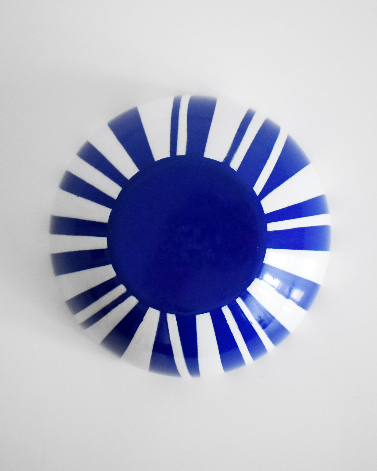 overhead shot of the bottom of a vintage blue and white striped Cathrineholm bowl on a white background