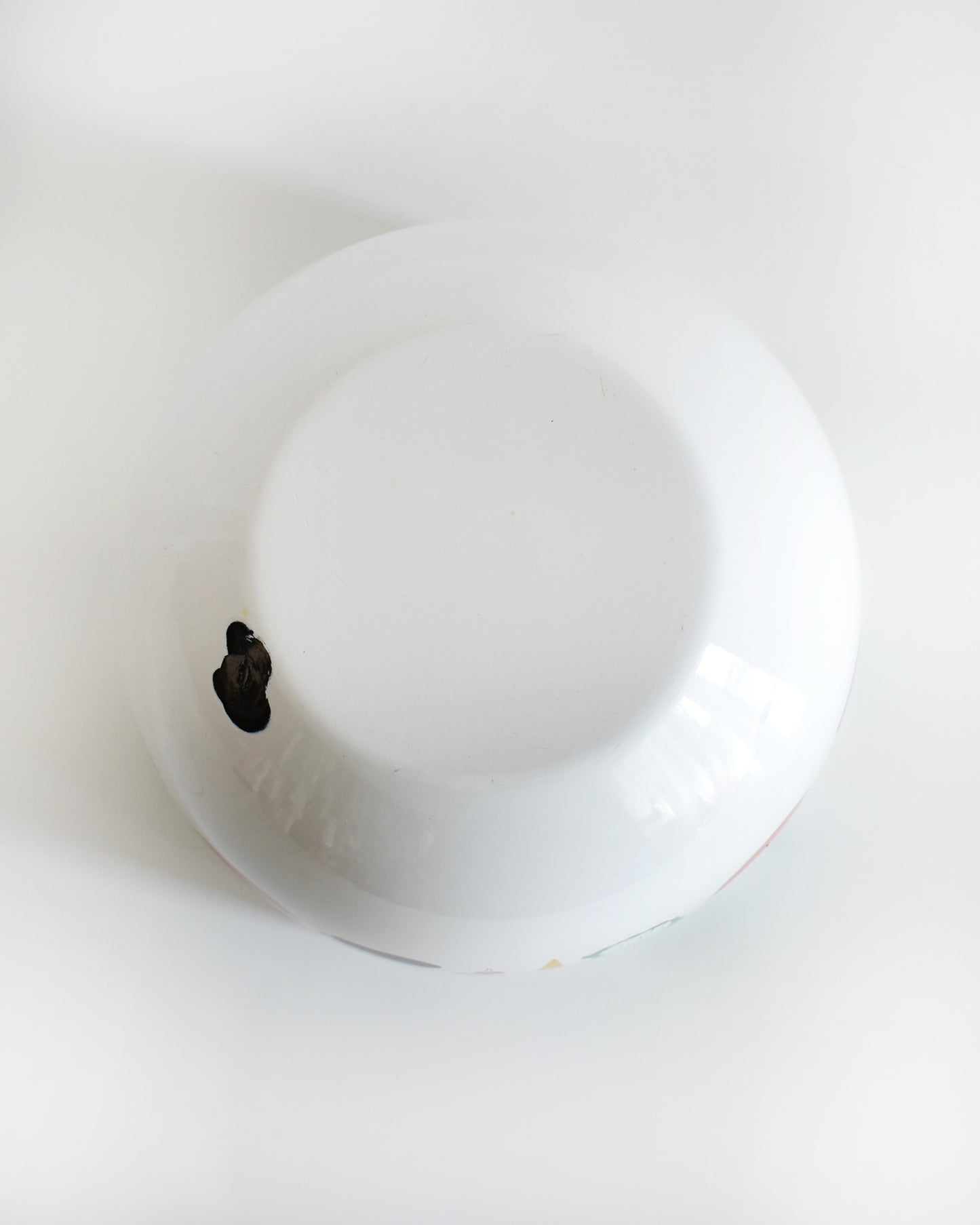 overhead shot of the bottom of a vintage Kaj Franck for Arabia Finland vegetable & fruit enamel bow. a spot of enamel is missing
