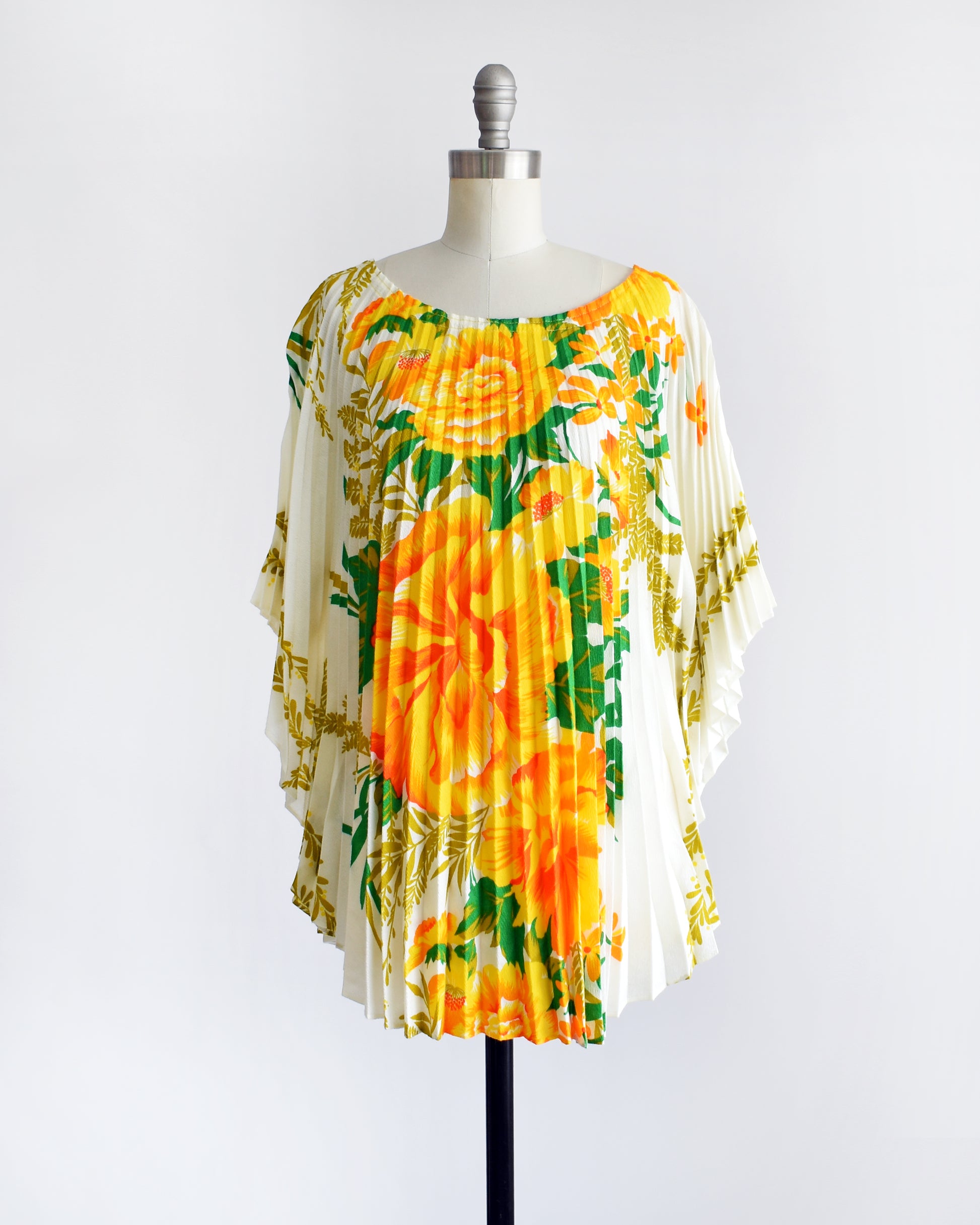 a vintage 1970s floral kaftan blouse on a dress form against a white background