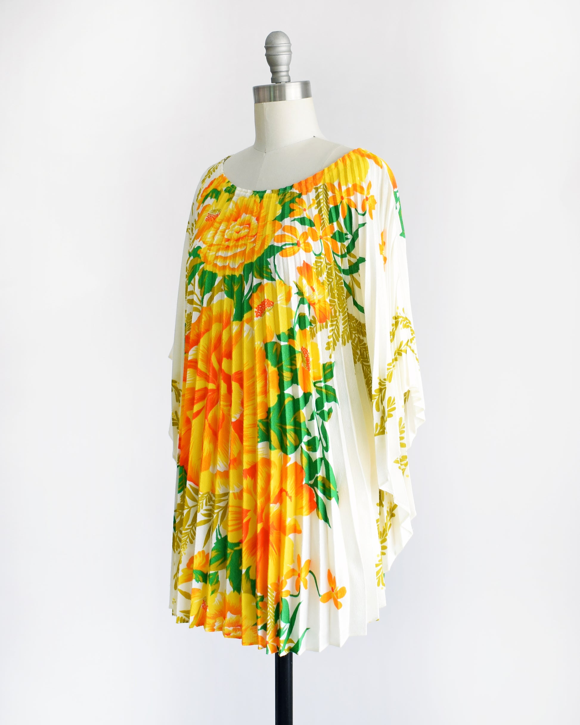 side front view of a vintage 1970s floral kaftan blouse on a dress form against a white background