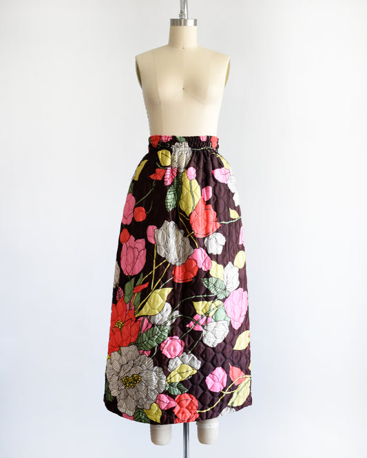 a vintage 1970s quilted skit that has a colorful floral print on a mannequin against a white background
