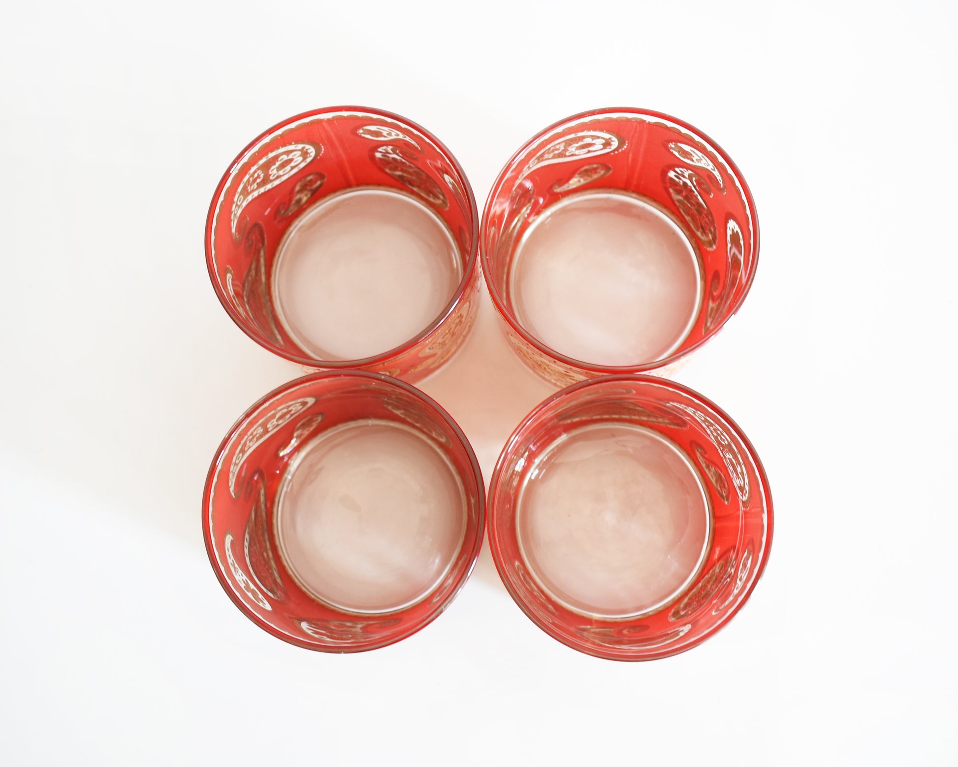 overhead shot of Vintage 1960s Red & Gold Paisley Glasses by Culver on a white background