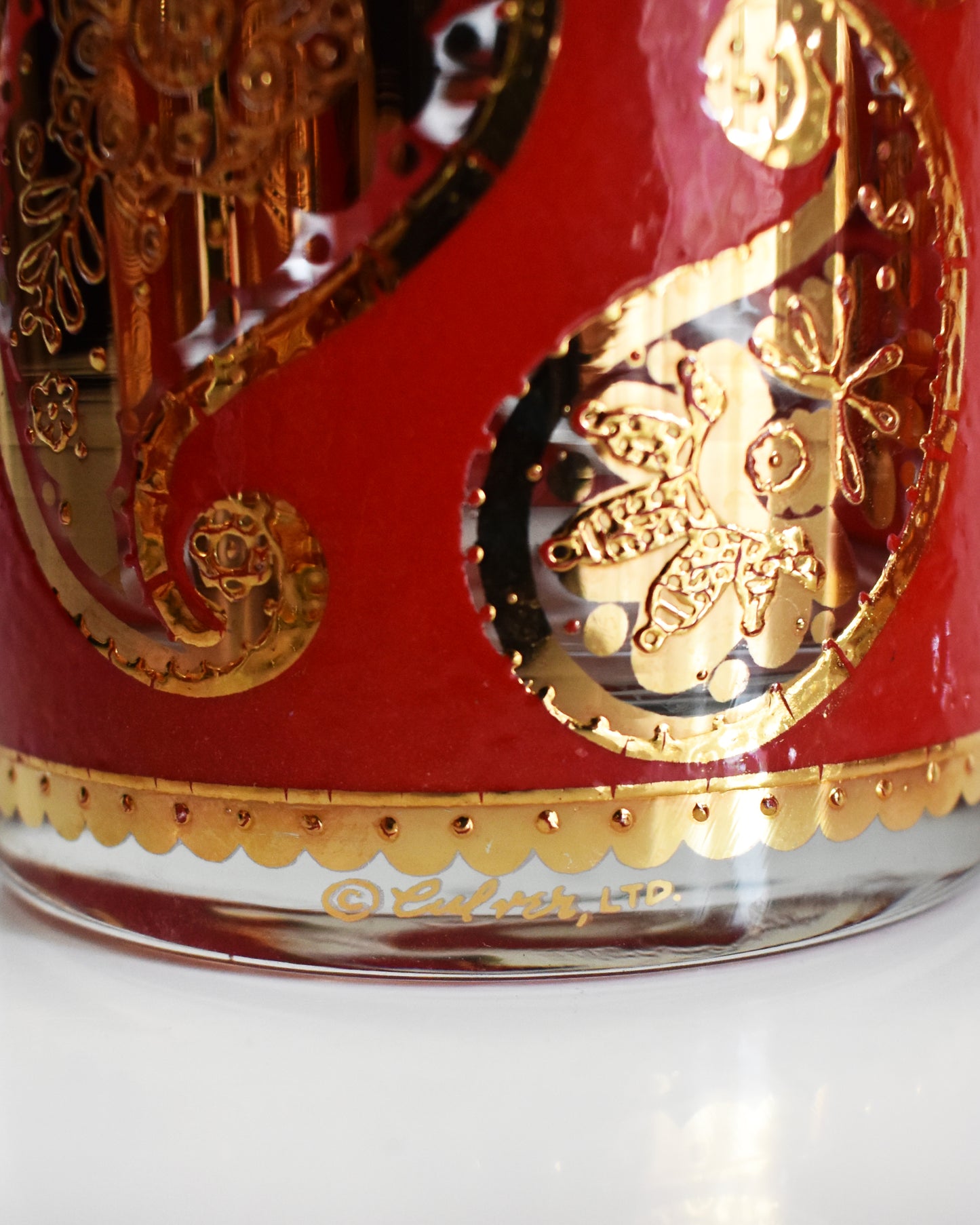 close up of the Culver signature on a vintage 1960s Red & Gold Paisley Glasses by Culver on a white background