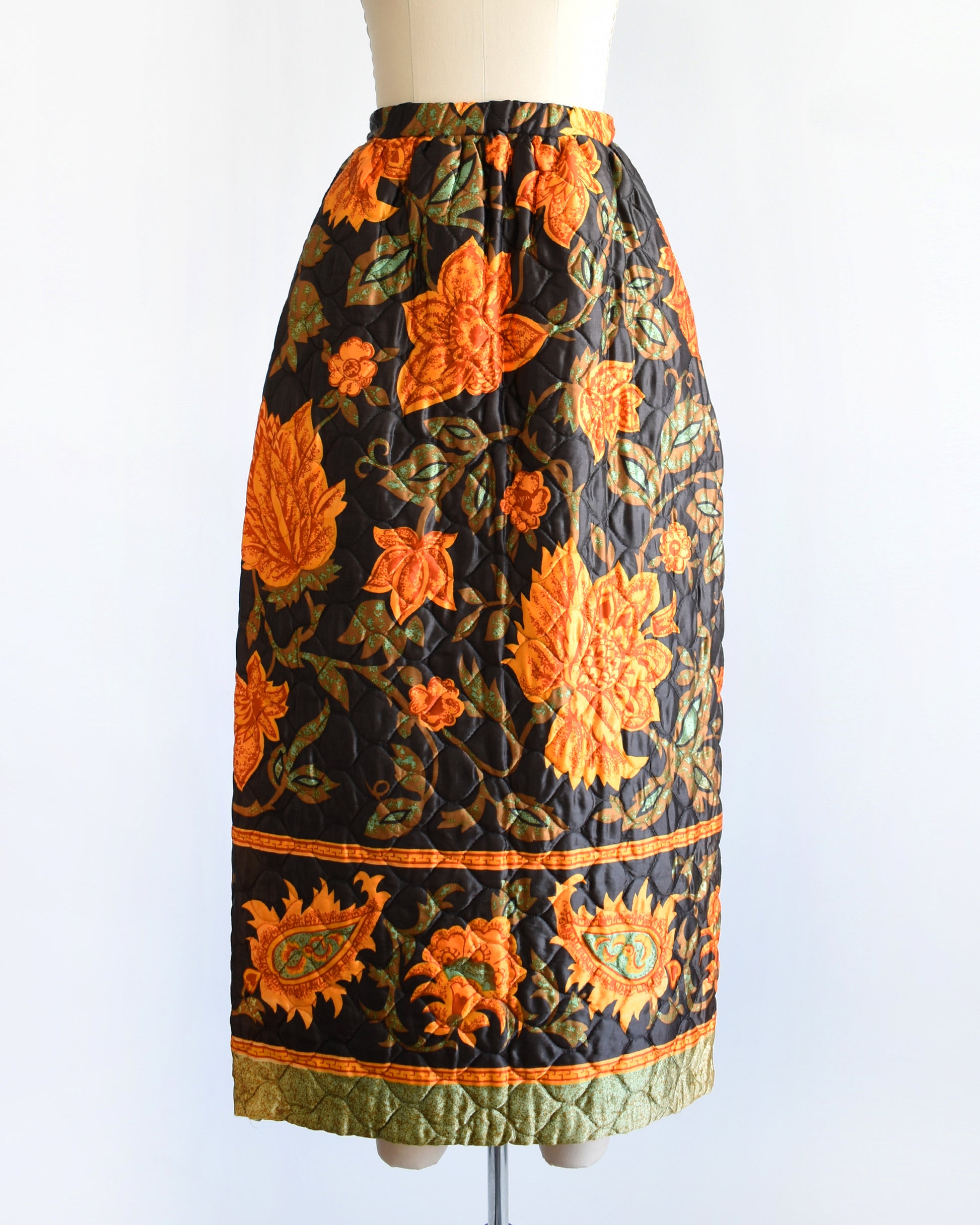 a vintage 1970s dark brown and orange floral patterned maxi skirt on a mannequin against a white background