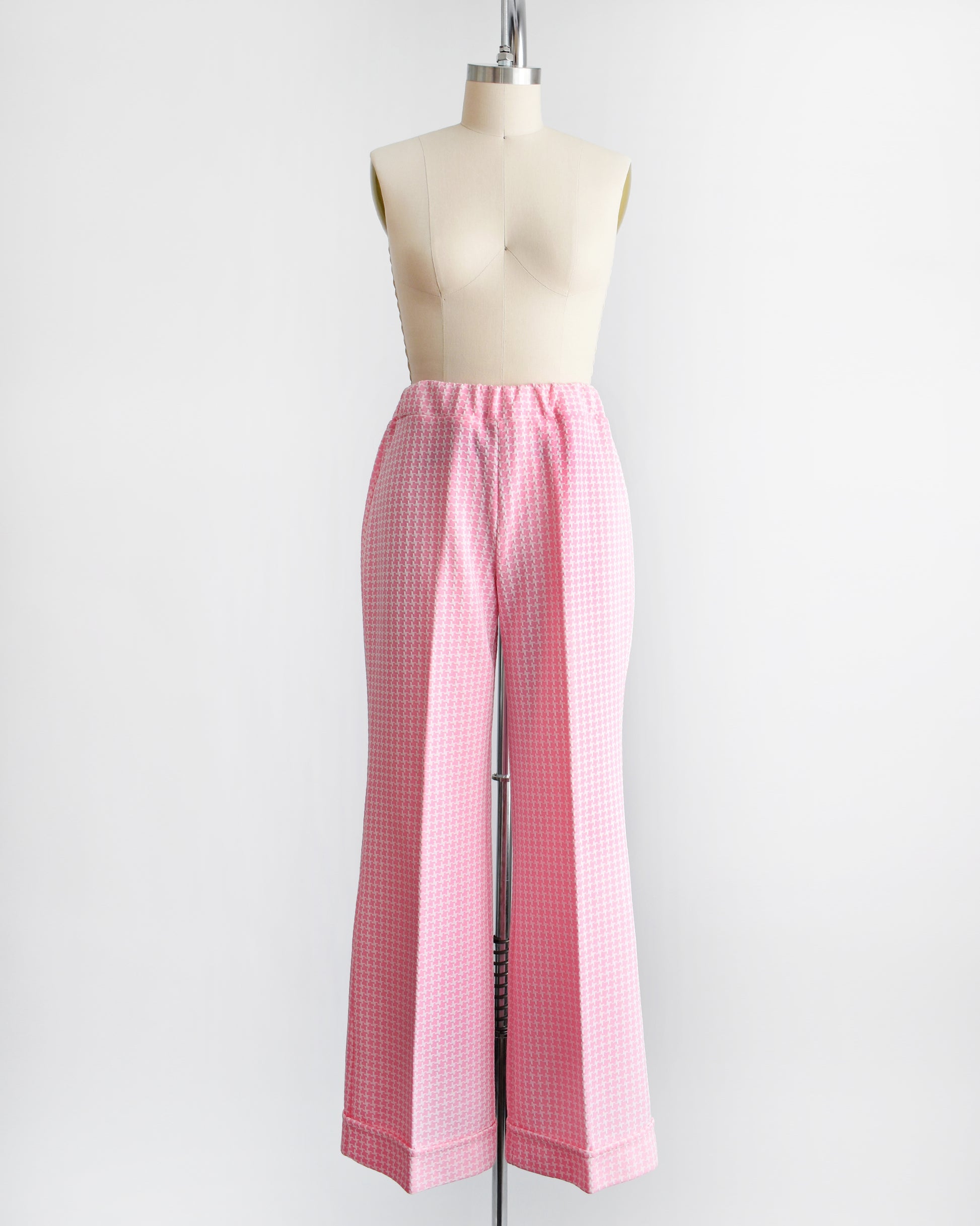 Vintage 1970s pink  and white houndstooth print wide leg pants on a dress form