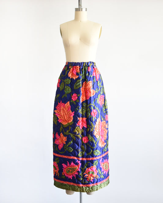 a vintage 1970s blue and pink floral patterned maxi skirt on a mannequin against a white background