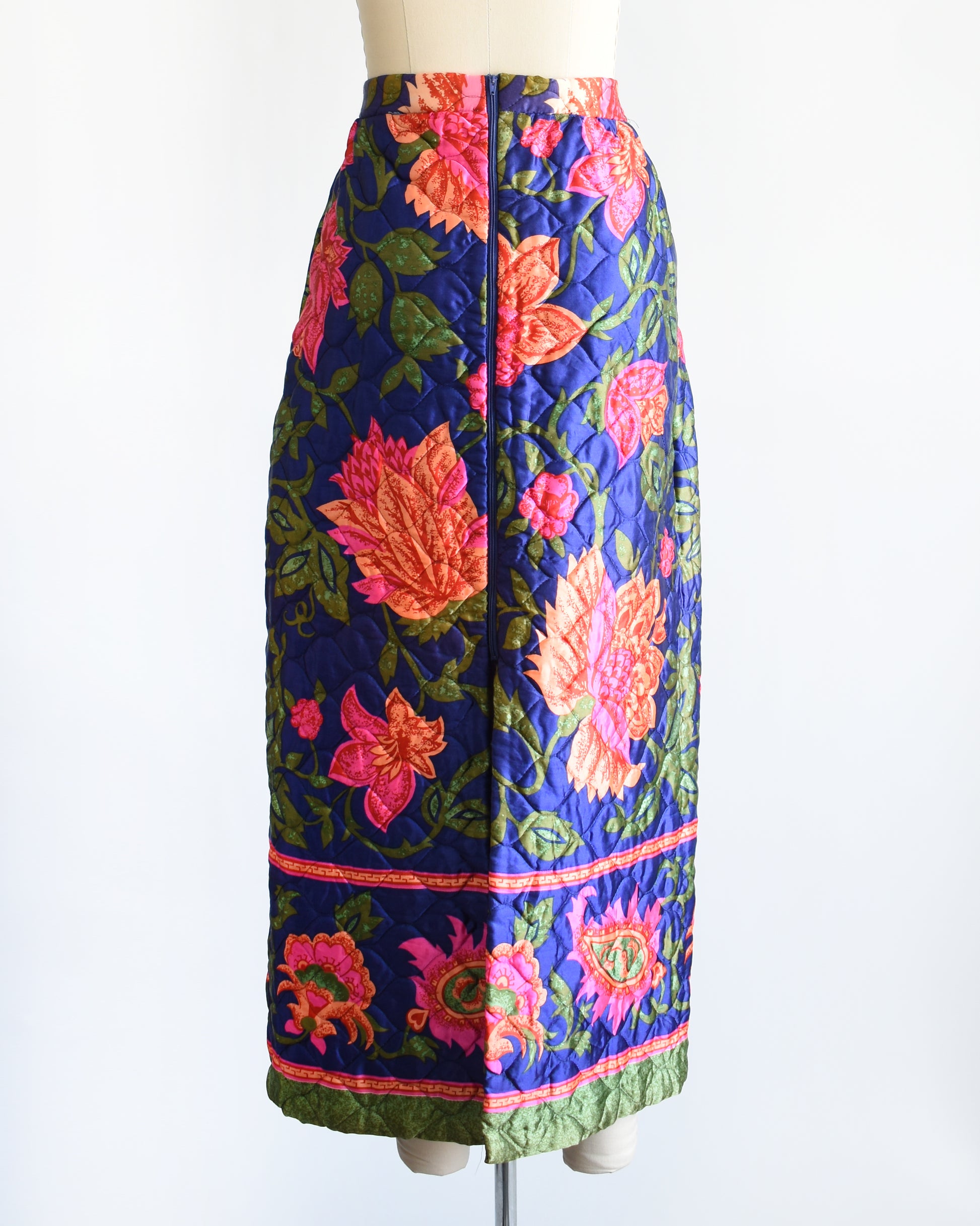 back view of a vintage 1970s blue and pink floral patterned maxi skirt on a mannequin against a white background