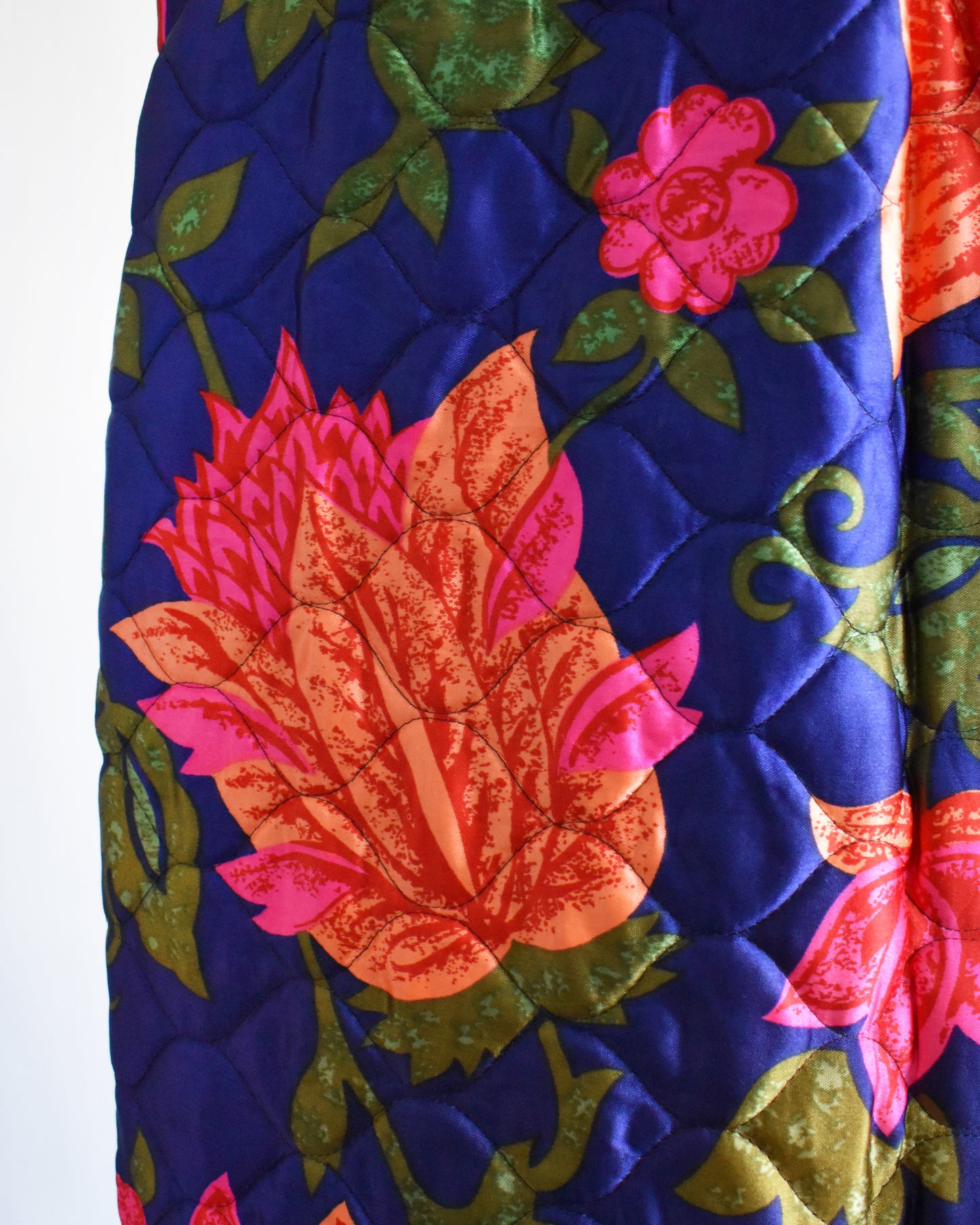 close up of the a vintage 1970s blue and pink floral patterned maxi skirt on a mannequin against a white background