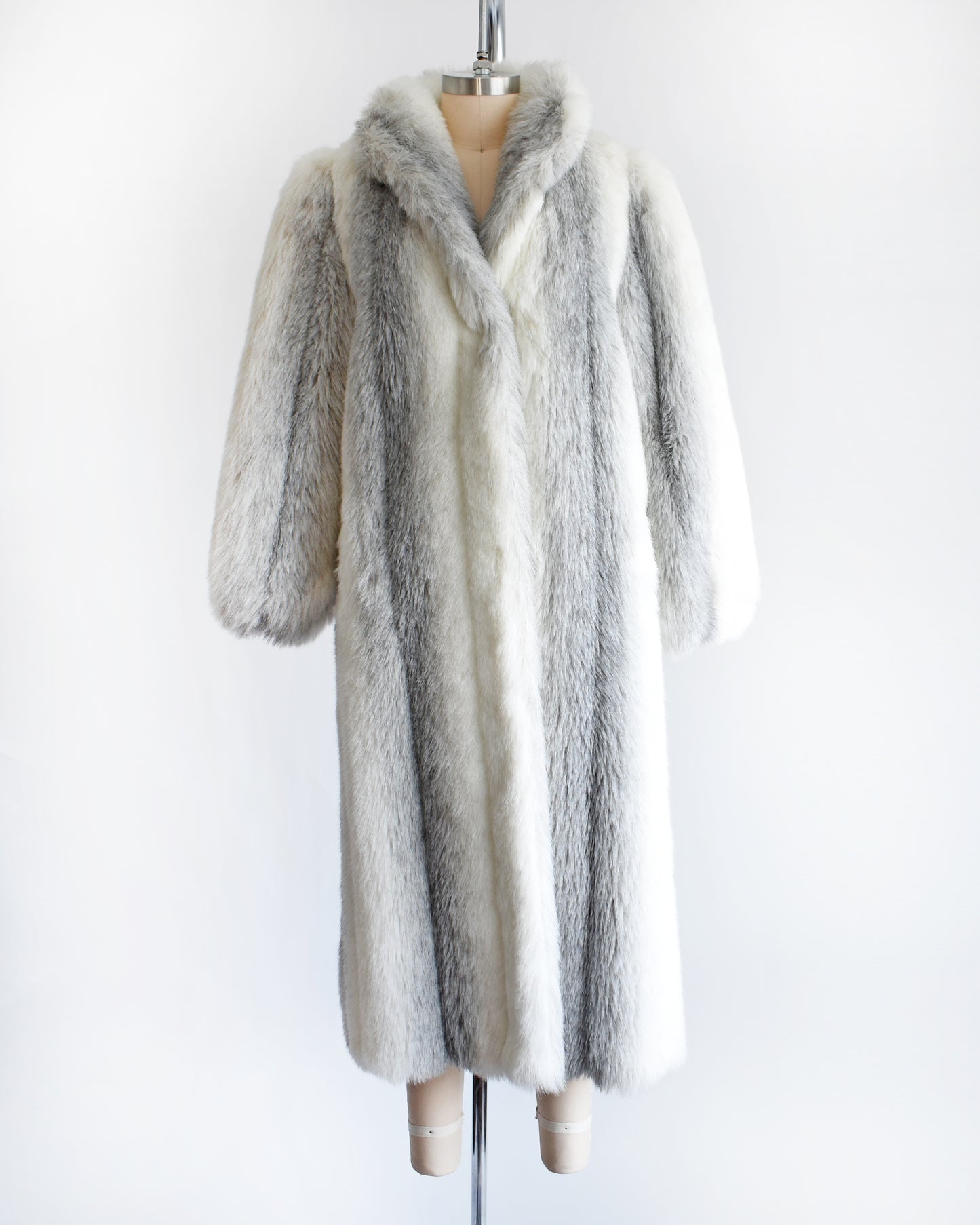 a vintage 1980s faux fur coat on a mannequin against a white background