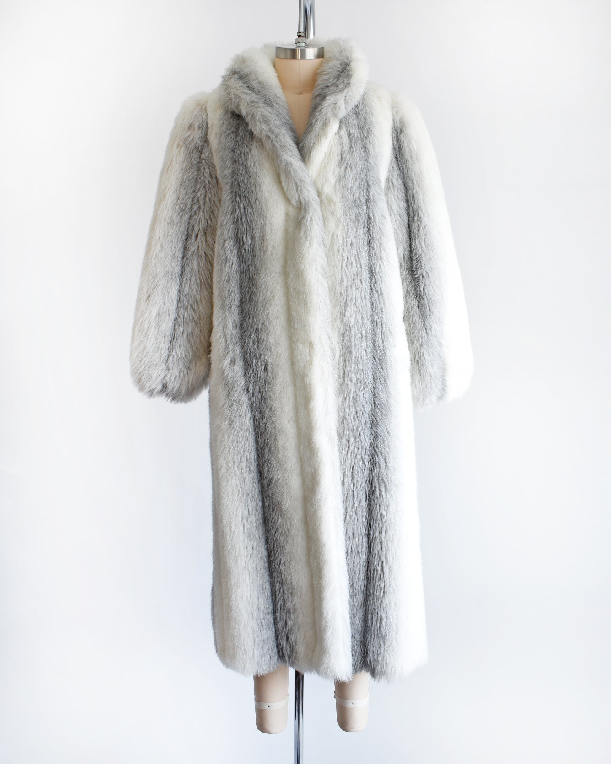 a vintage 1980s faux fur coat on a mannequin against a white background