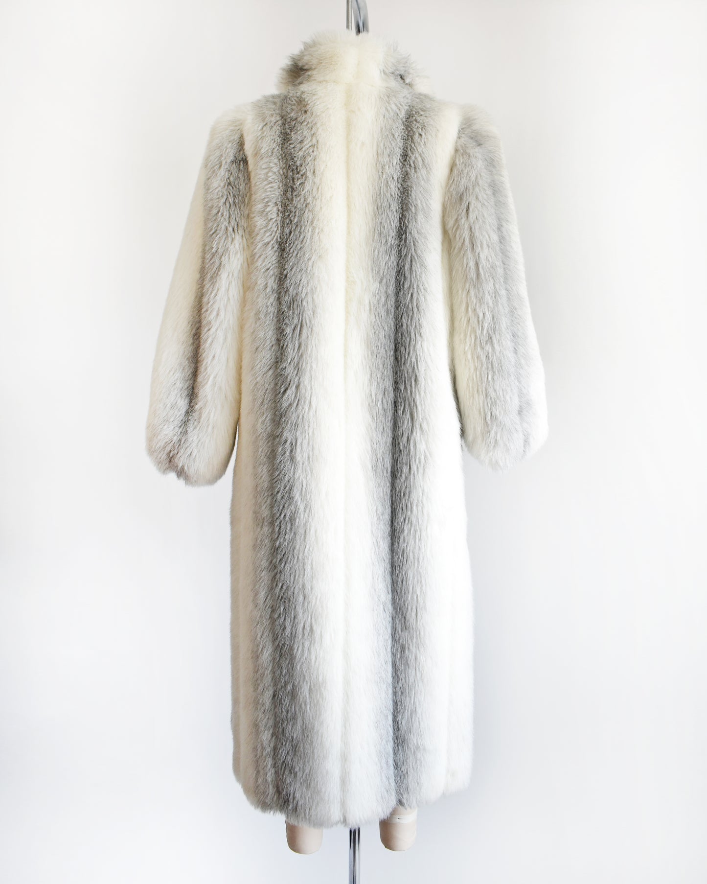 back view of a vintage 1980s faux fur coat on a mannequin against a white background