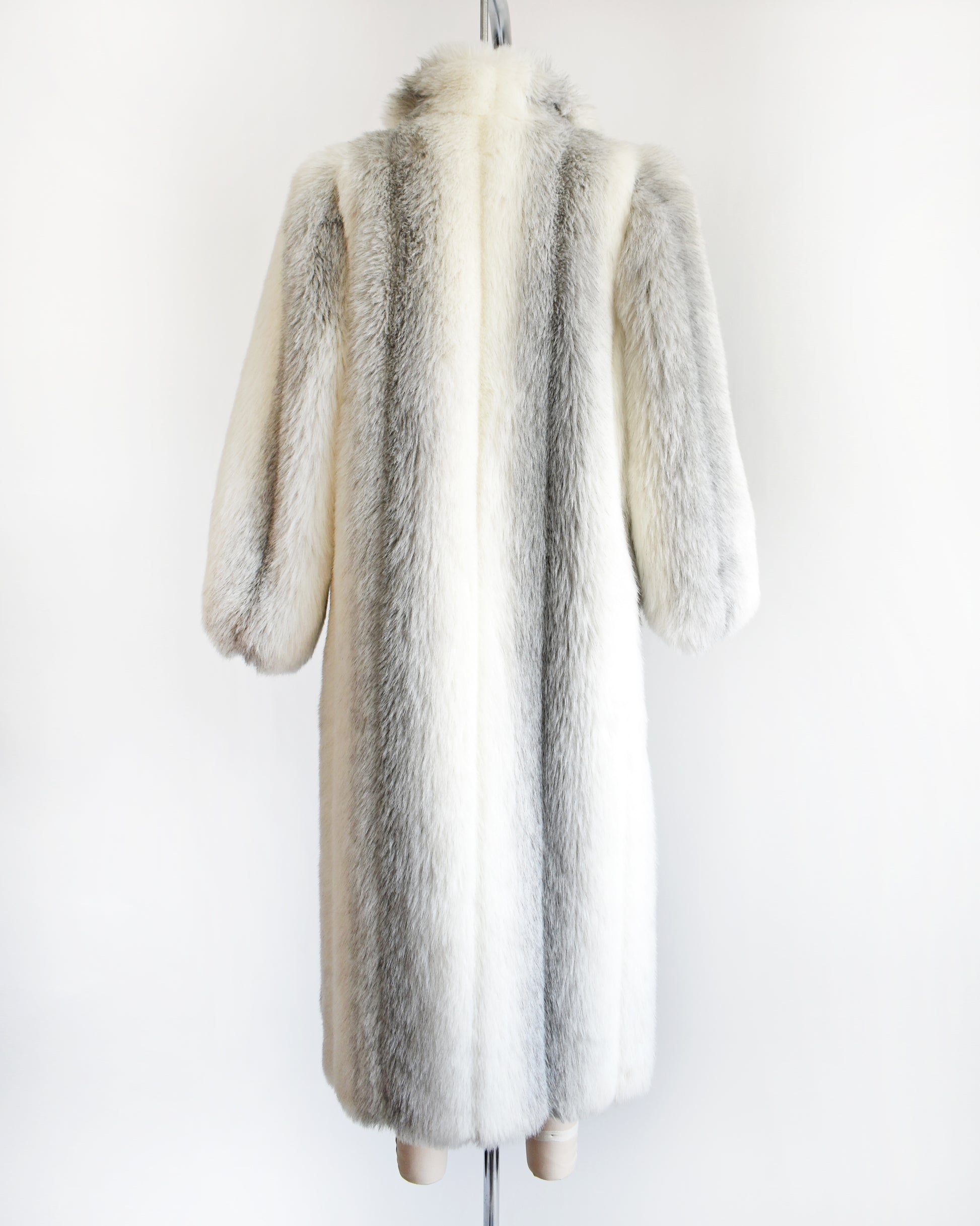 back view of a vintage 1980s faux fur coat on a mannequin against a white background