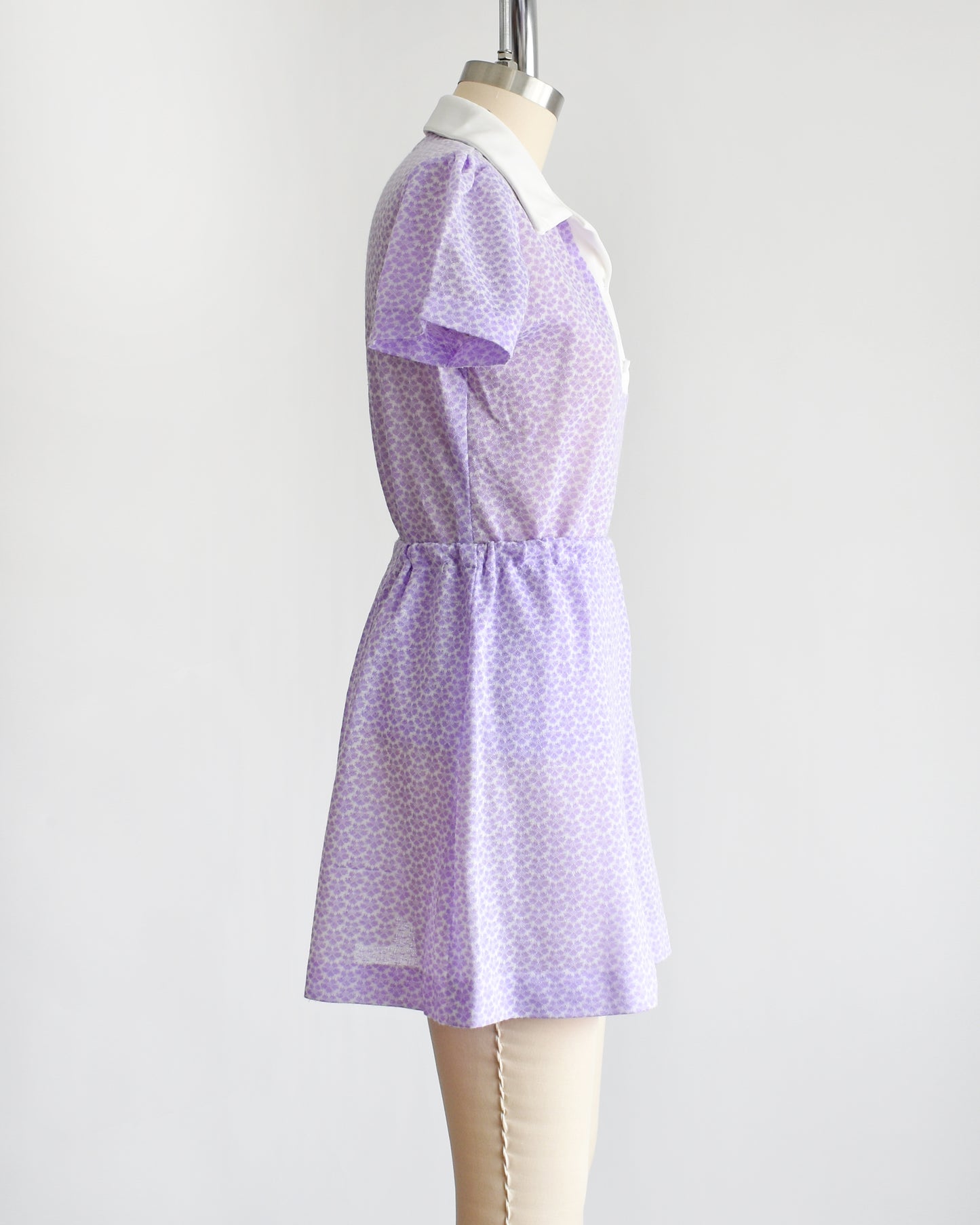 side view of a vintage 1970s mod floral purple blouse and skirt set