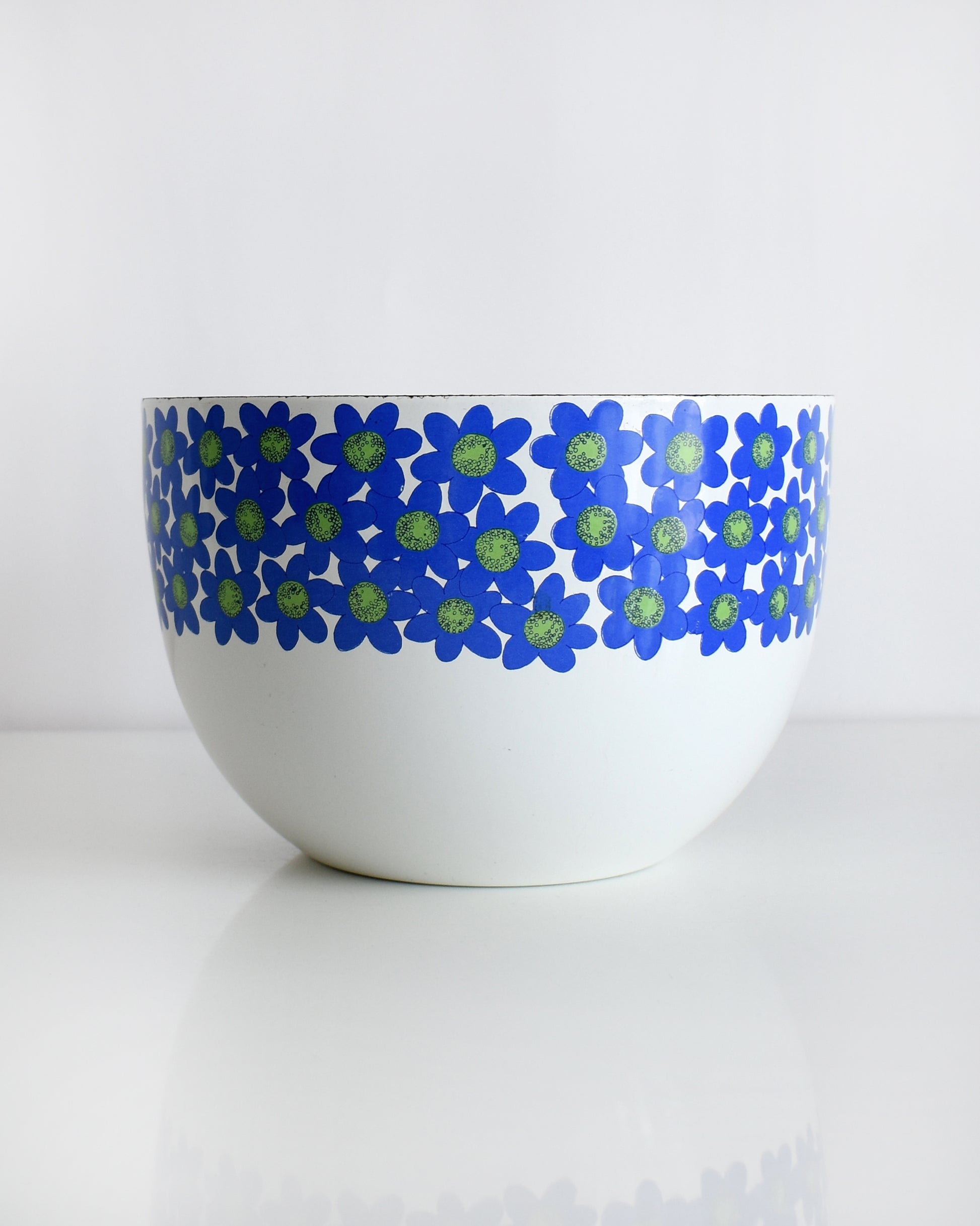 a vintage white 1970s Finel Arabia Finland bowl with blue and green flowers around the rim set against a clean white background.