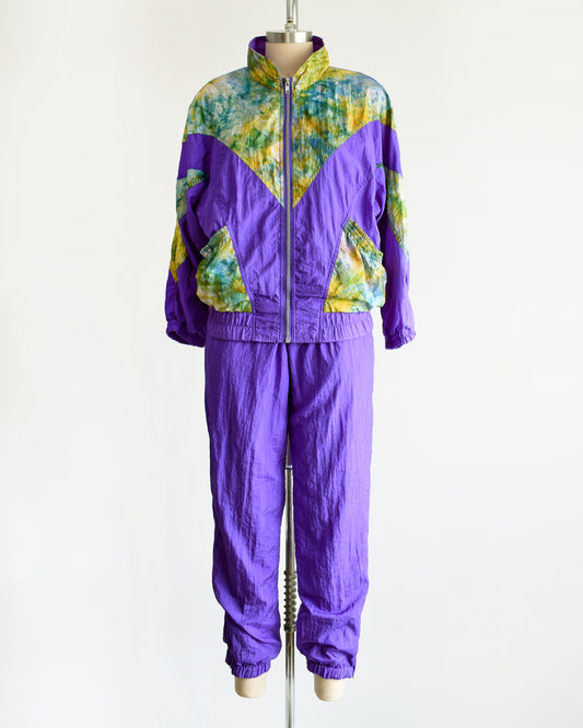 A vintage 1990s purple and multicolored tracksuit on a mannequin against a white background