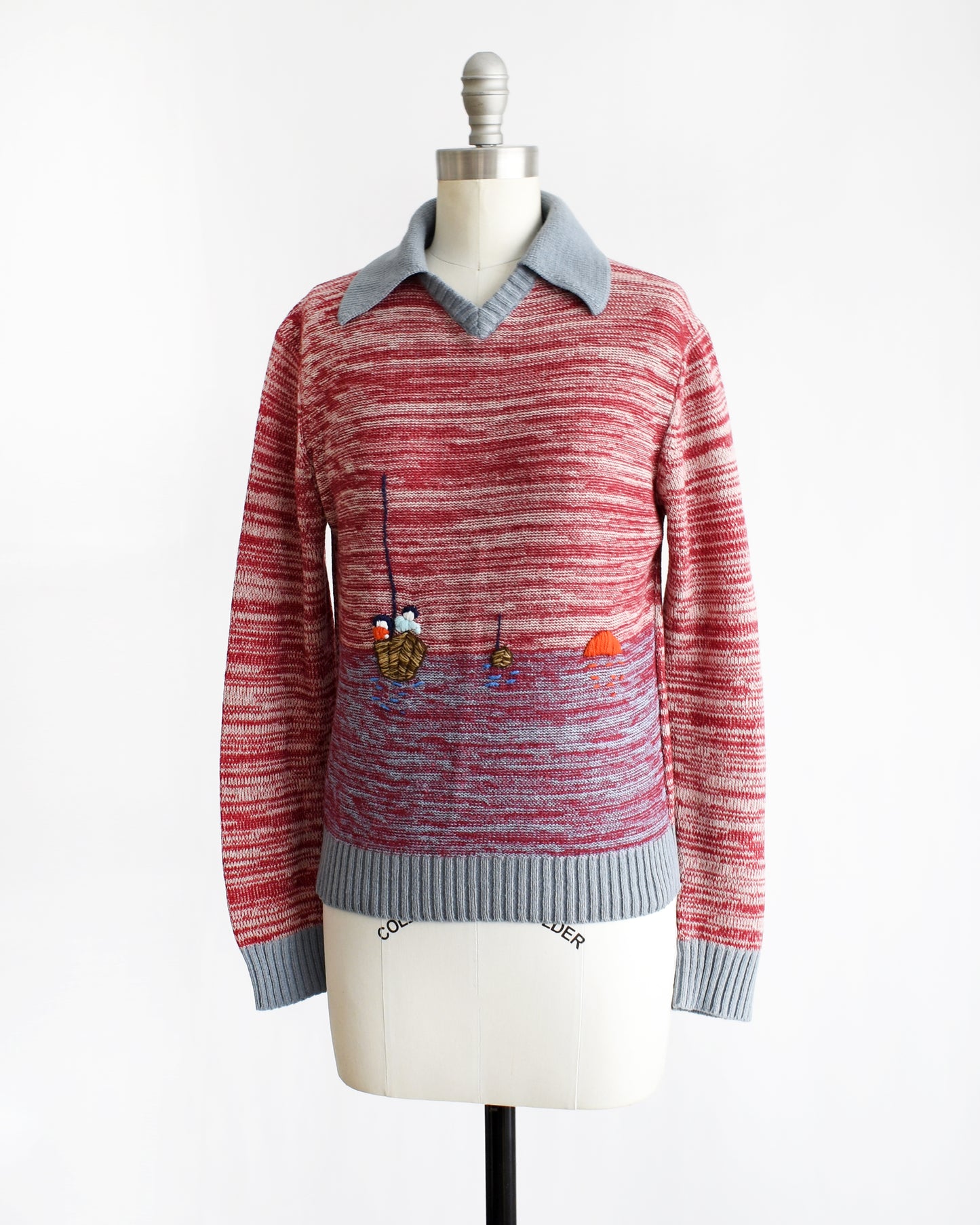 side front view of a vintage 1970s red space dye sweater with fishing boating design on a mannequin against a white background