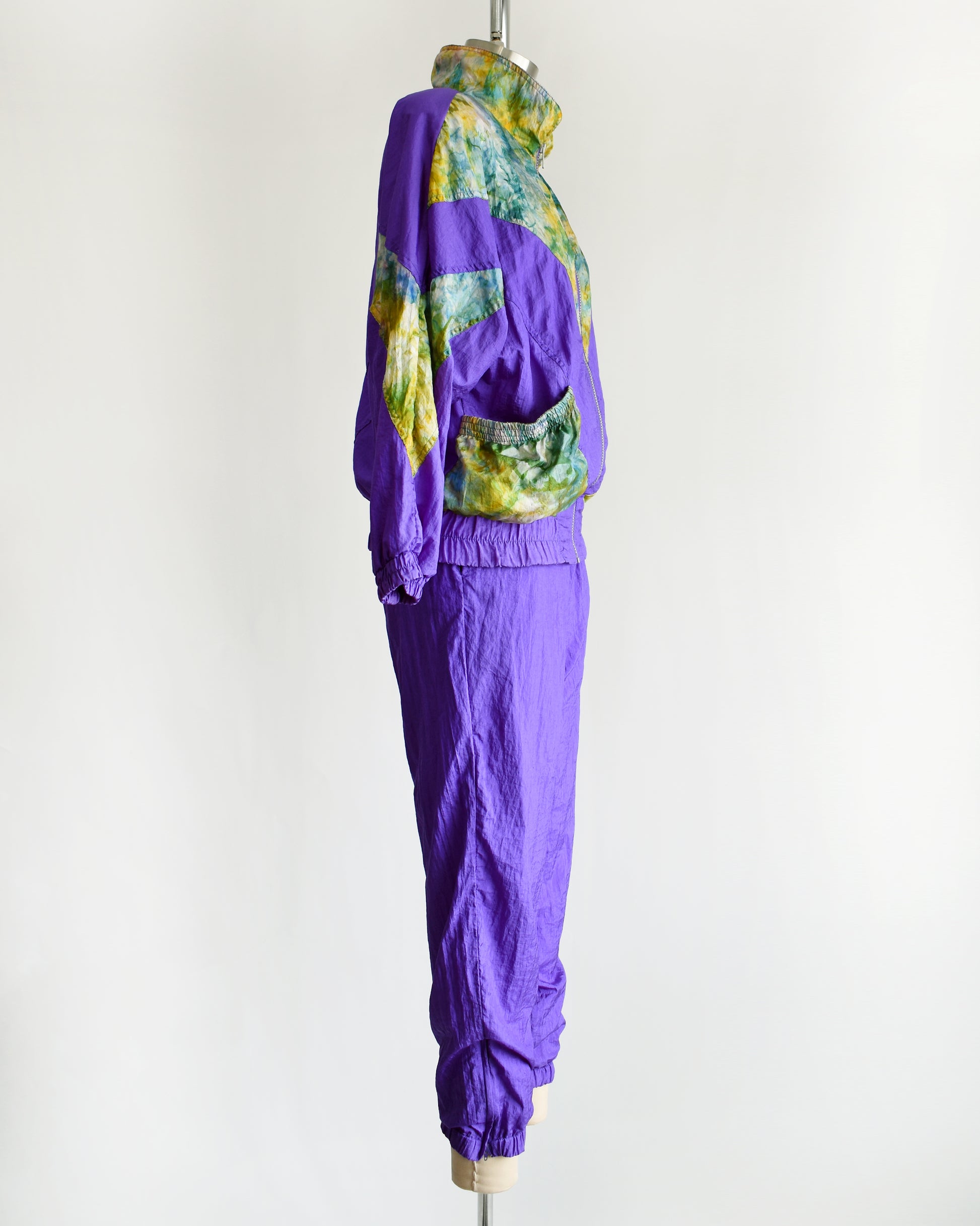 side view of a vintage 1990s purple and multicolored tracksuit on a mannequin against a white background