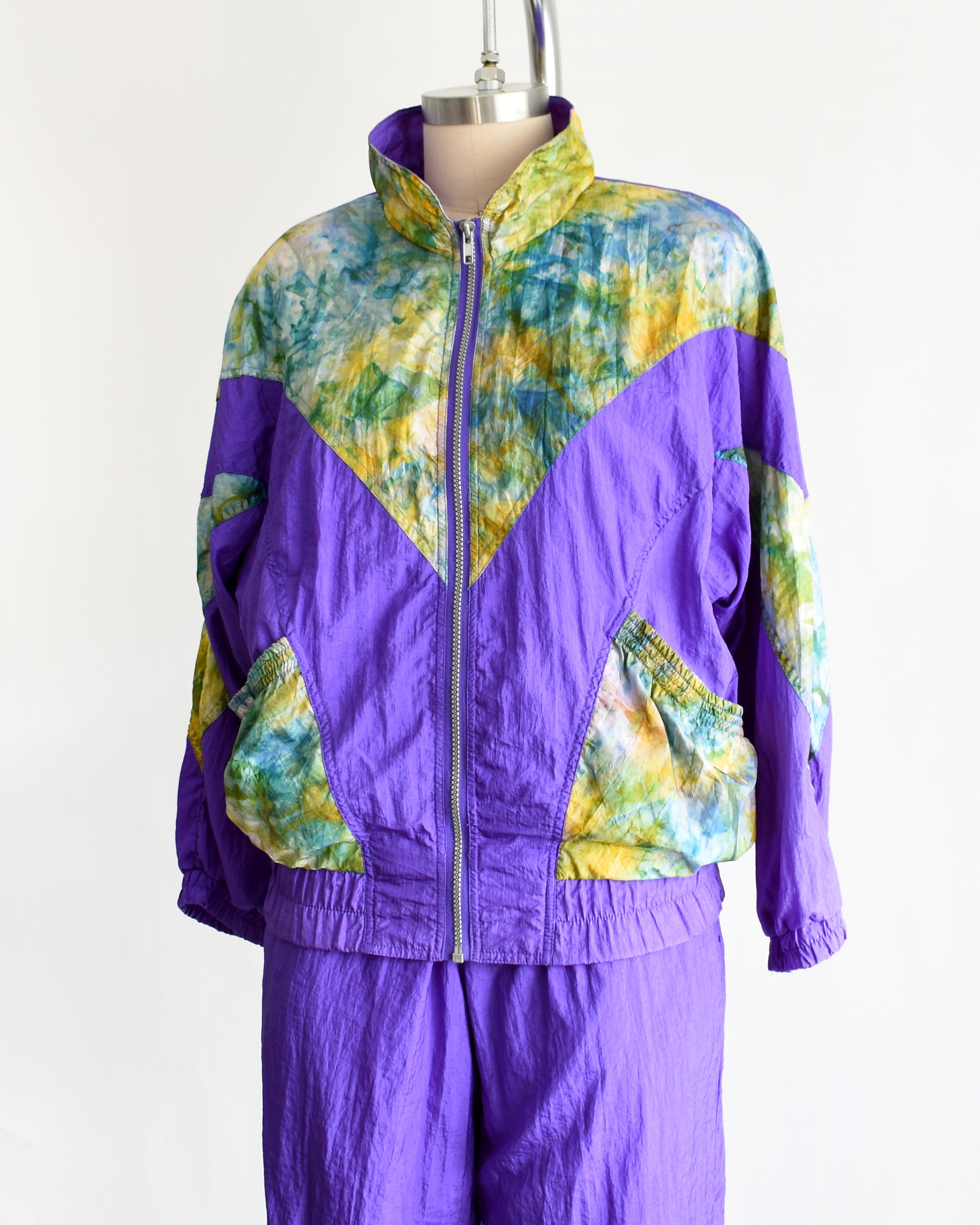 side font view of a vintage 1990s purple and multicolored tracksuit on a mannequin against a white background