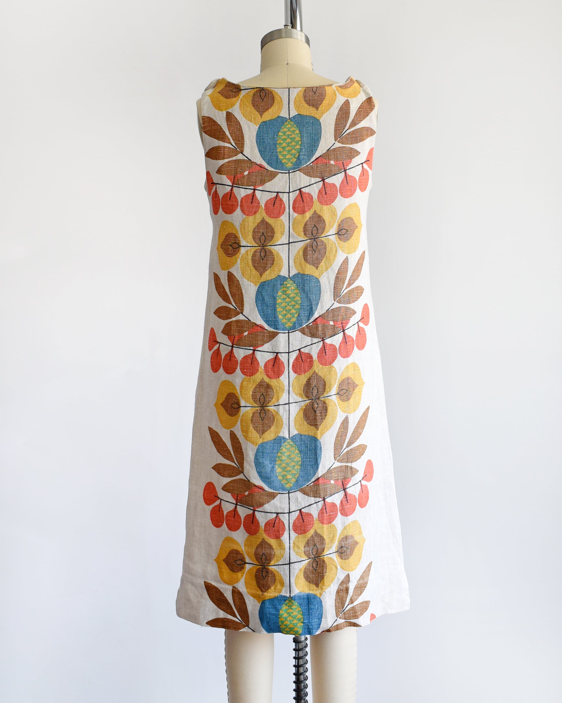 back view of a vintage 1960s shift dress with a colorful mid century floral print on the front and back.