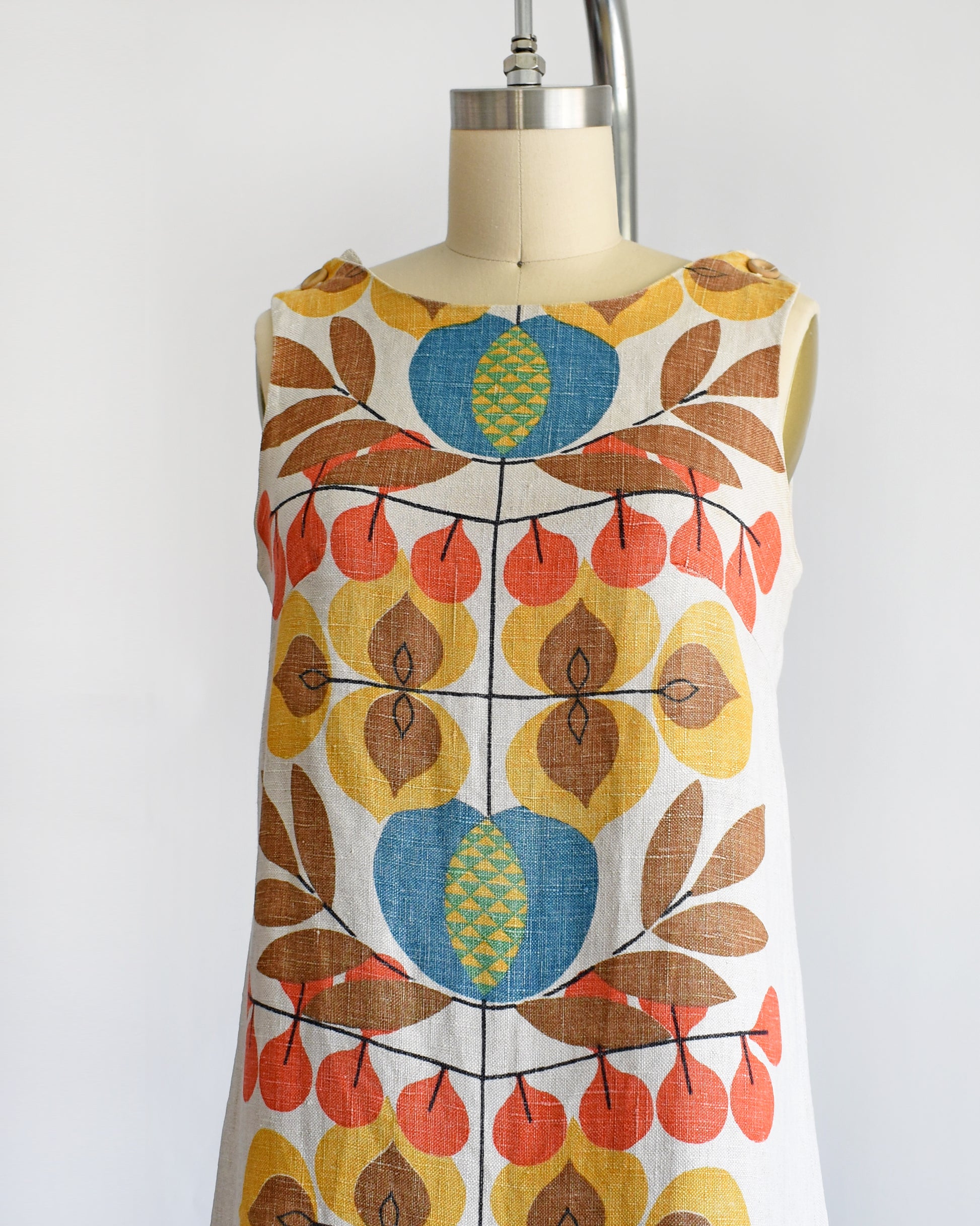 side front view of a vintage 1960s shift dress with a colorful mid century floral print on the front and back.