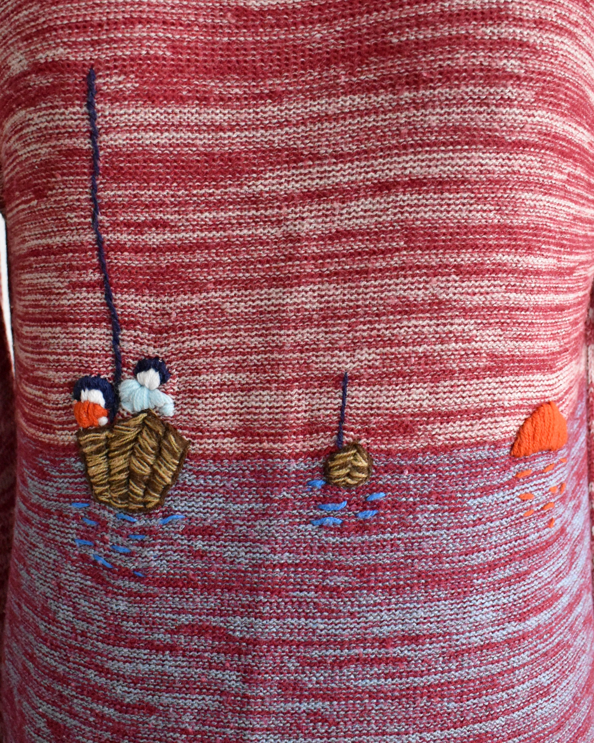 close up of the embroidered boat design on the sweater