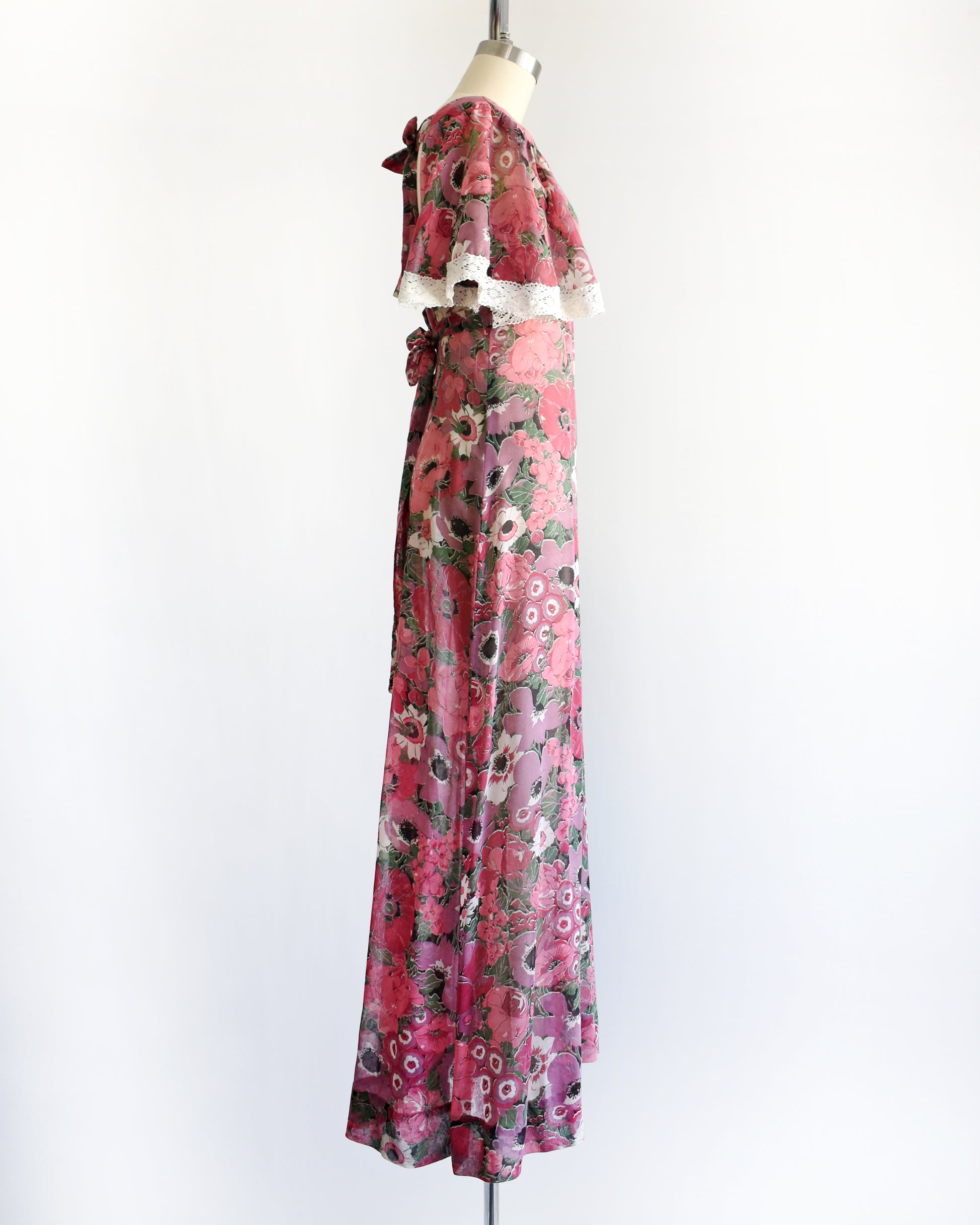 side view of a vintage 1970s floral dress on a mannequin against a white background