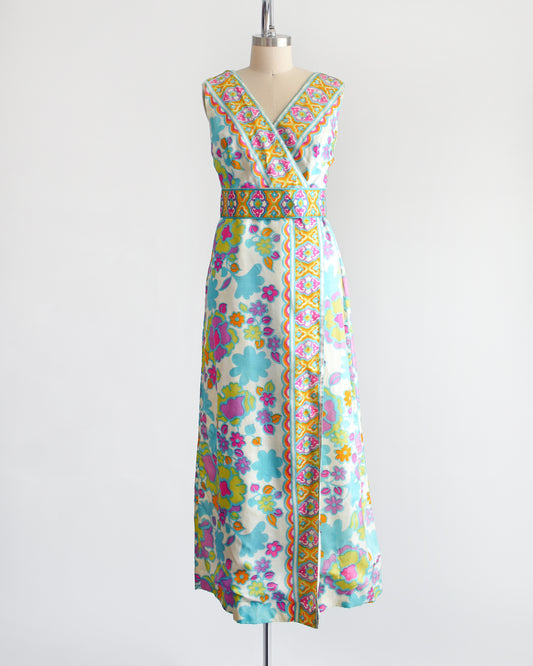 a vintage 1960s white gown with a colorful floral print and matching belt