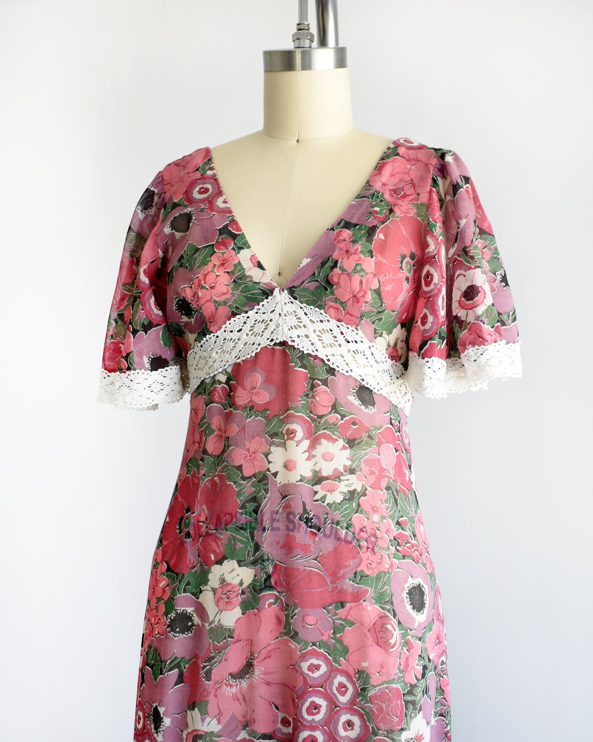 side front view of a vintage 1970s floral dress on a mannequin against a white background