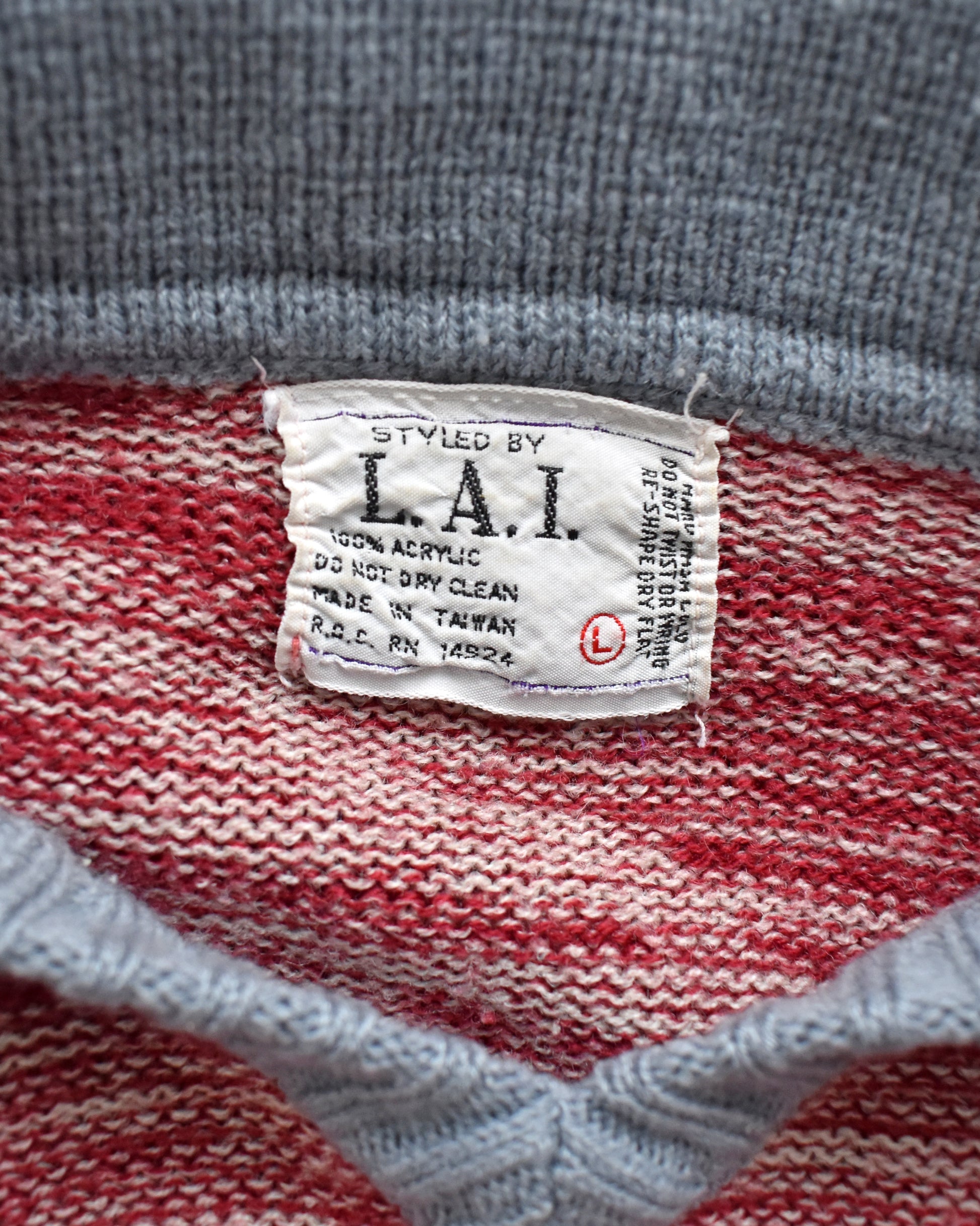 Close-up of a label on a red and gray striped fabric with 'L.A.I.' branding.