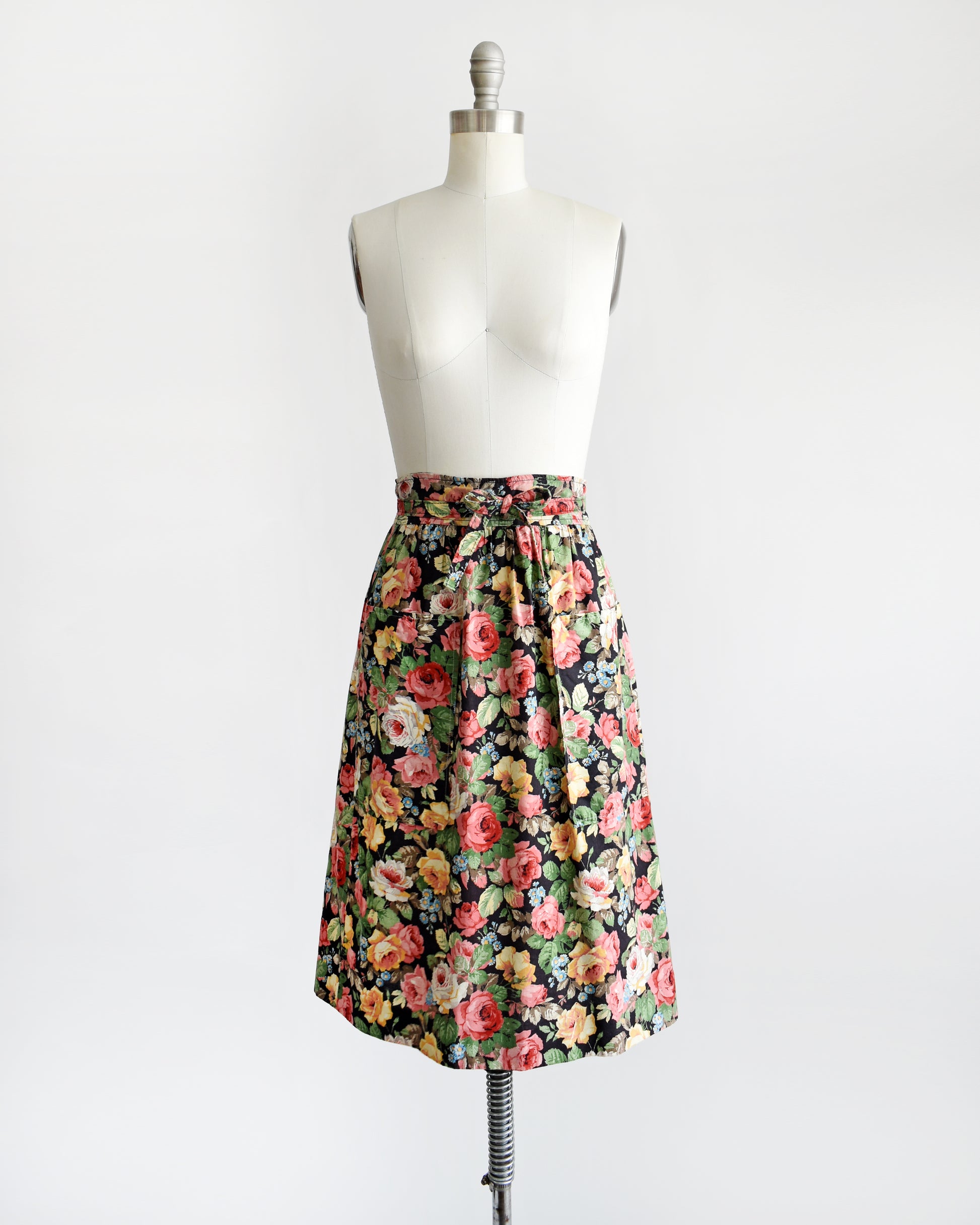 a vintage 1970s black floral wrap skirt that has two large pockets on the front