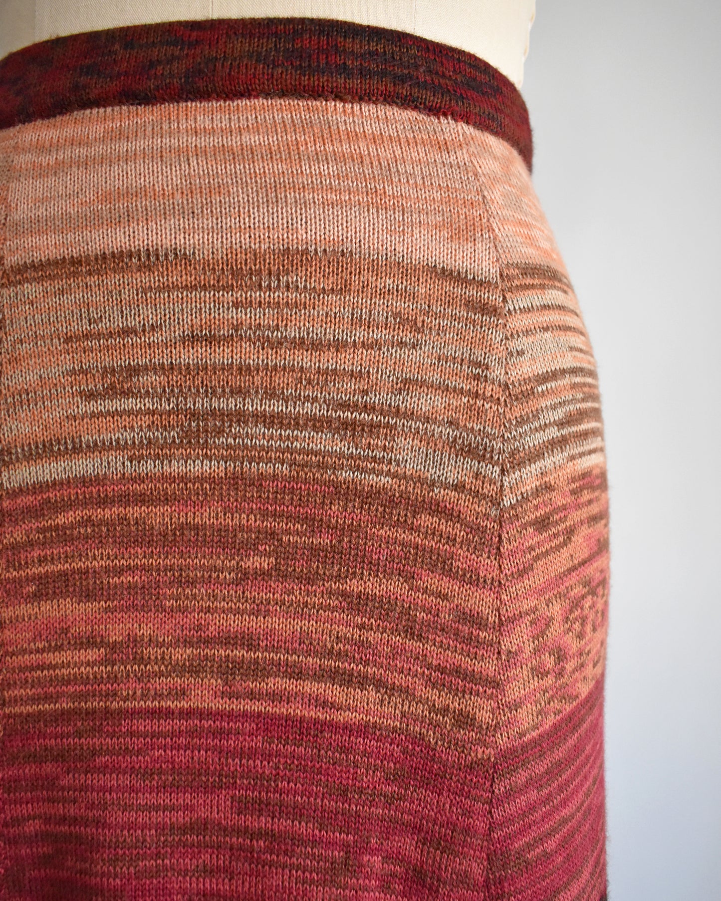Close-up of a textured skirt with a gradient pattern on a plain background