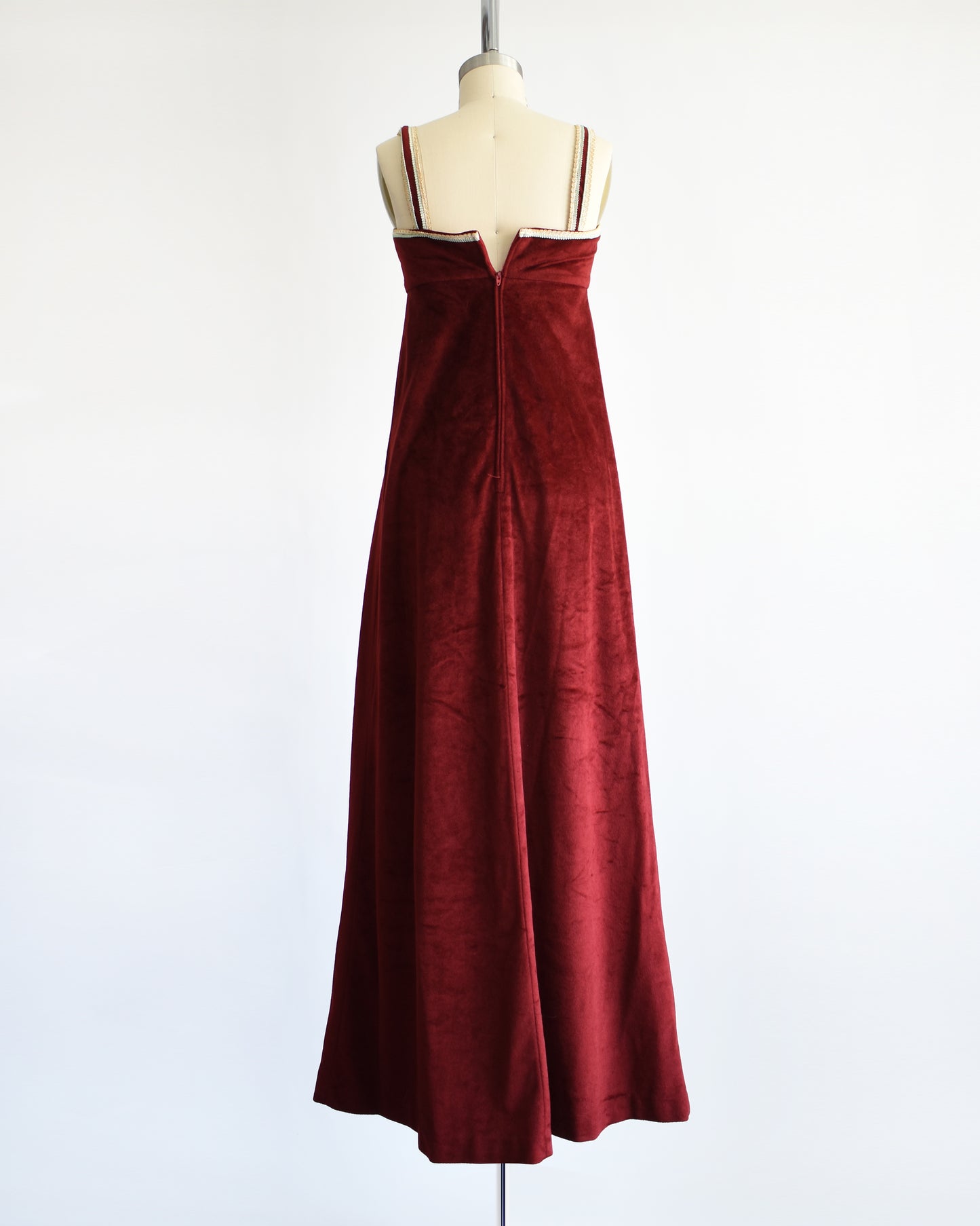 back view A vintage 1970s burgundy velvet maxi dress. the zipper isn'z zipped up all the way because of my dress form, but it does go all the way up